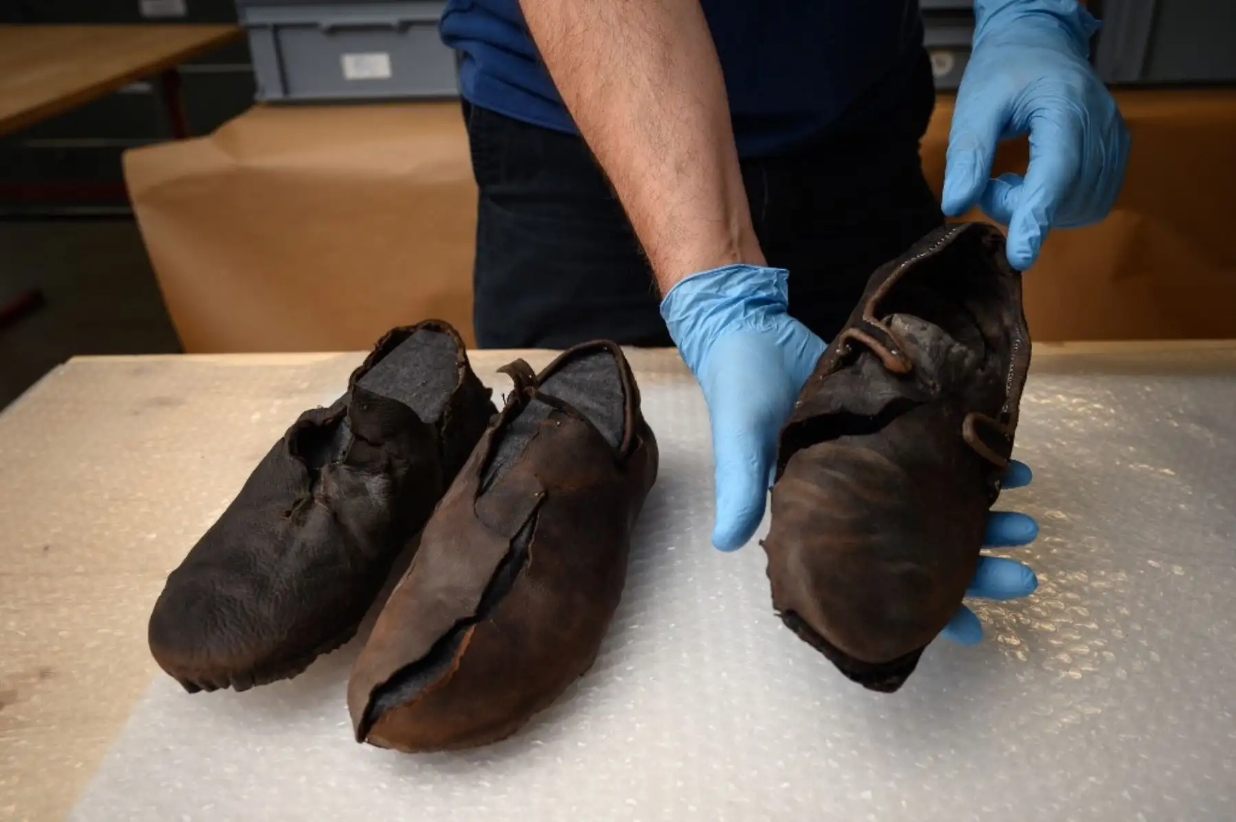 Una fotografía en Sion muestra la mano de Pierre Yves Nicod, curador del departamento arqueológico del museo de historia del cantón de Valais, que muestra un zapato del siglo XVII encontrado en un glaciar en el cantón de Valais, en el sur de Suiza. Foto: AFP