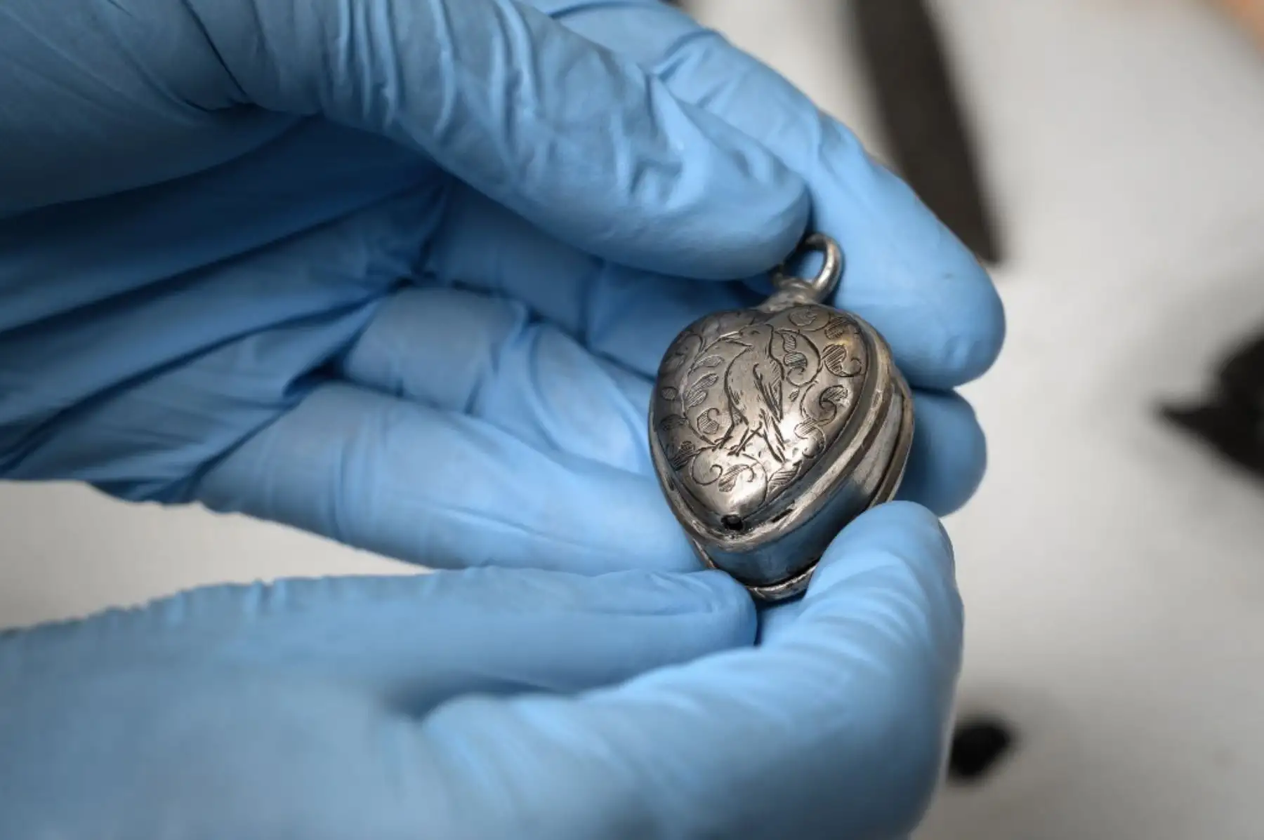 Una fotografía tomada en Sion muestra la mano de Pierre Yves Nicod, curador del departamento arqueológico del museo de historia del cantón de Valais, sosteniendo un colgante del siglo XVII encontrado en un glaciar en el cantón de Valais, en el sur de Suiza. Foto: AFP