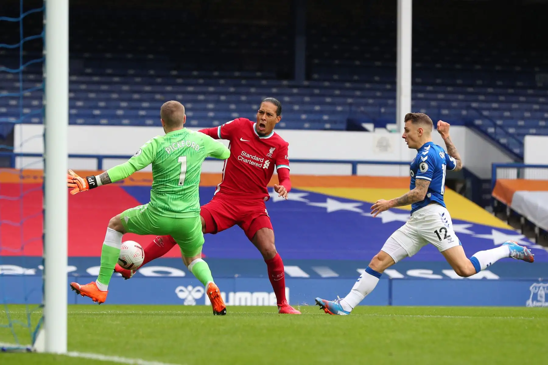 El portero inglés de Everton, Jordan Pickford, aborda al defensor holandés de Liverpool Virgil van Dijk durante el partido de fútbol de la Premier League en Goodison Park, Liverpool. Foto: AFP