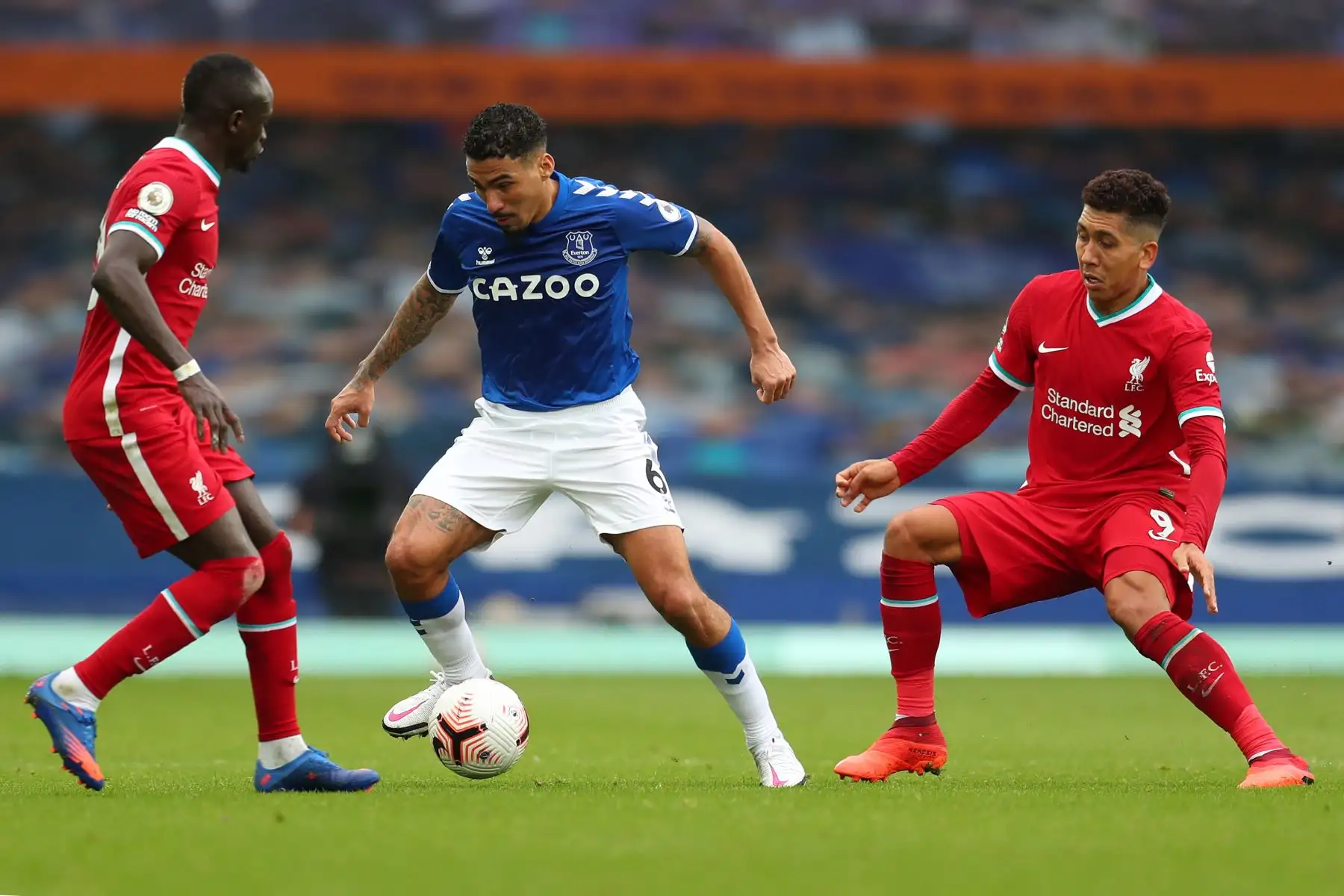 El mediocampista brasileño del Everton, Allan, compite con el delantero senegalés de Liverpool, Sadio Mane y el mediocampista brasileño de Liverpool, Roberto Firmino, durante el partido de fútbol de la Premier League en Goodison Park, Liverpool. Foto: AFP