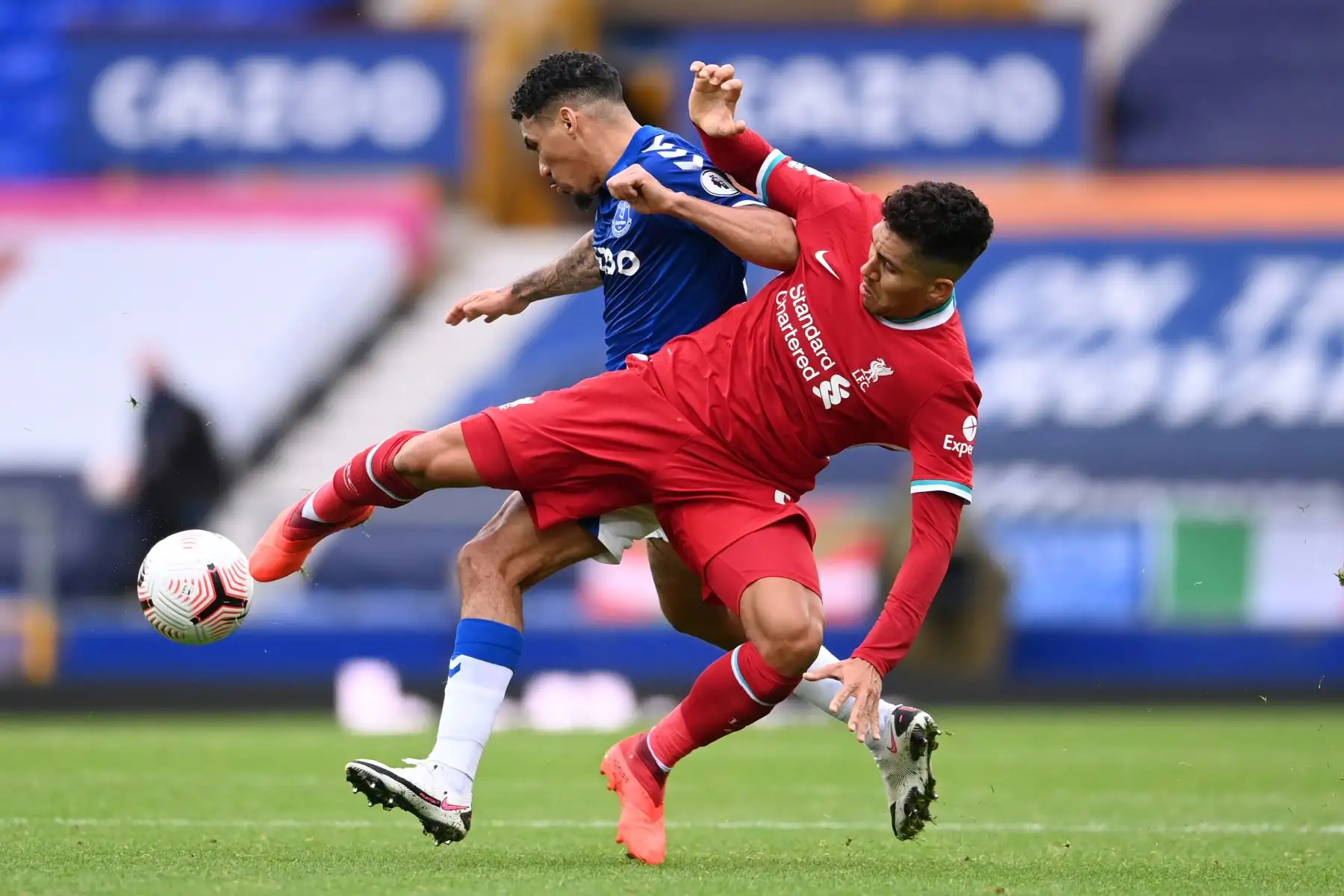 El mediocampista brasileño del Liverpool, Roberto Firmino, compite con el mediocampista brasileño del Everton, Allan, durante el partido de fútbol de la Premier League en Goodison Park, Liverpool. Foto: AFP