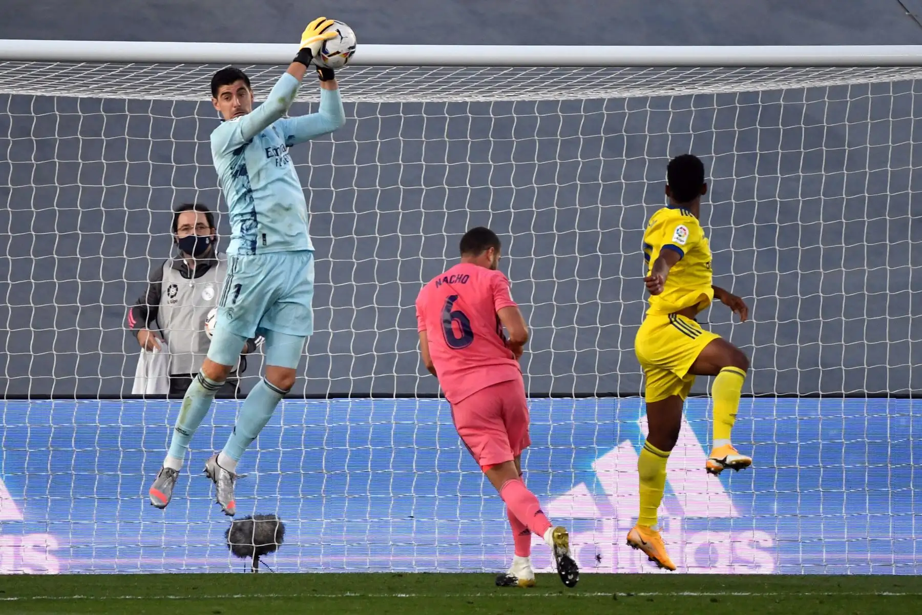 El portero belga del Real Madrid, Thibaut Courtois, salta para atrapar el balón durante el partido de fútbol de la Liga española en el estadio Alfredo Di Stefano, en Valdebebas, noreste de Madrid. Foto: AFP