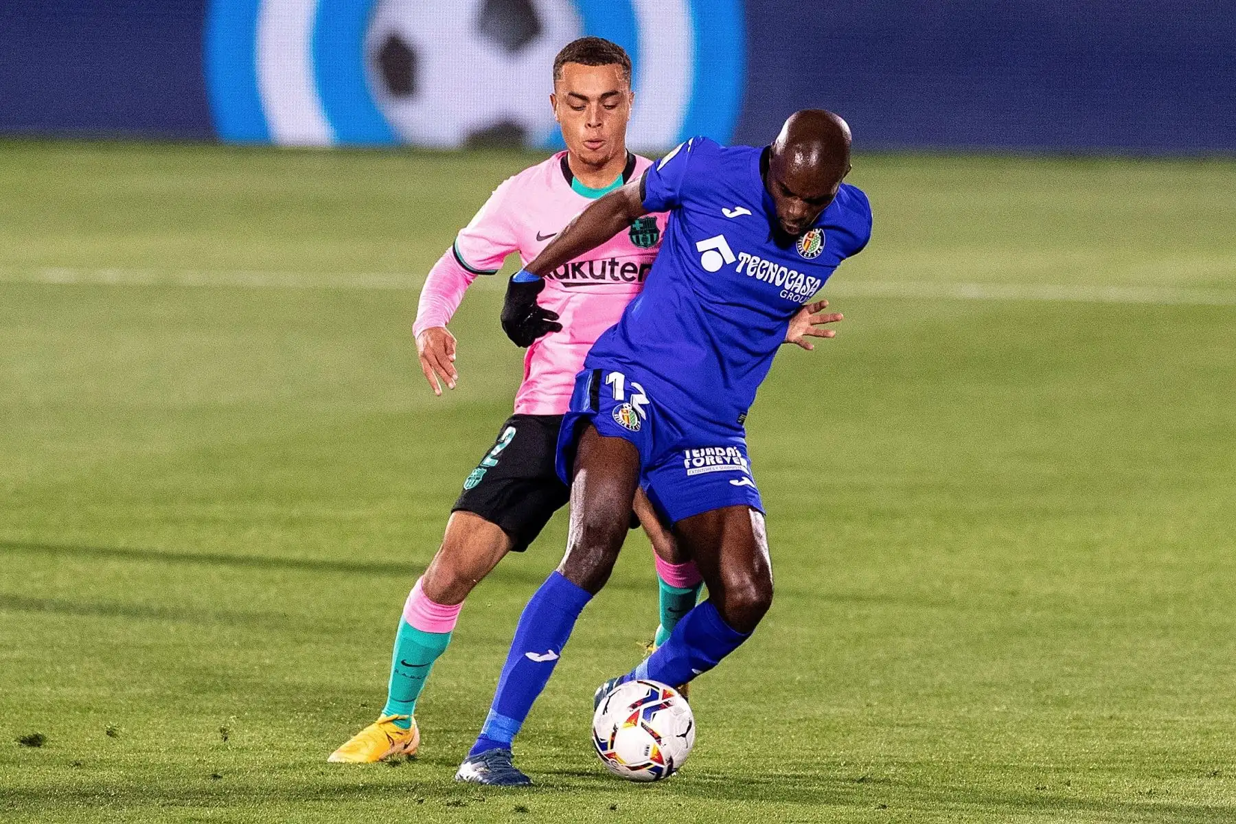 El jugador del Getafe, Allan Nyom, protege un balón ante Sergiño Dest del FC Barcelona ​​durante el partido de Liga que se disputa esta noche en el Coliseum Alfonso Pérez. Foto: EFE