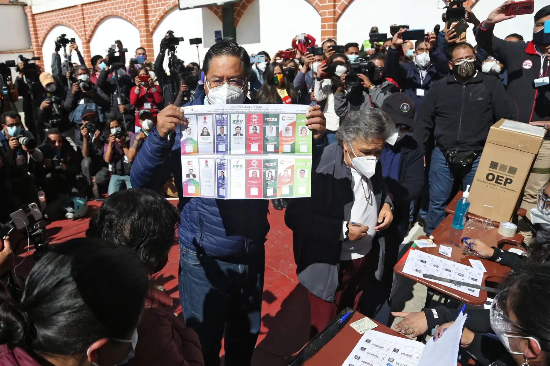 El candidato presidencial izquierdista de Bolivia, Luis Arce, del partido Movimiento por el Socialismo, muestra una papeleta mientras vota en un colegio electoral en La Paz, en medio de la pandemia por coronavirus. Foto: AFP