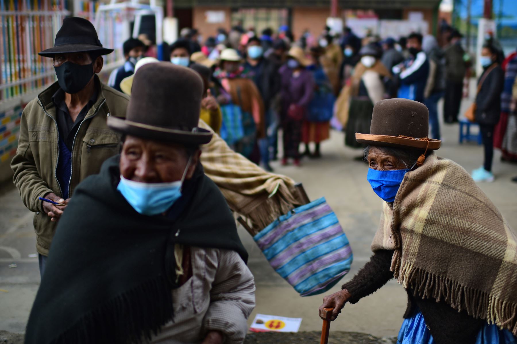 Personas de la zona rural hacen cola para emitir su voto electoral en un colegio de Huarina, Bolivia, en medio de la pandemia. Foto: AFP