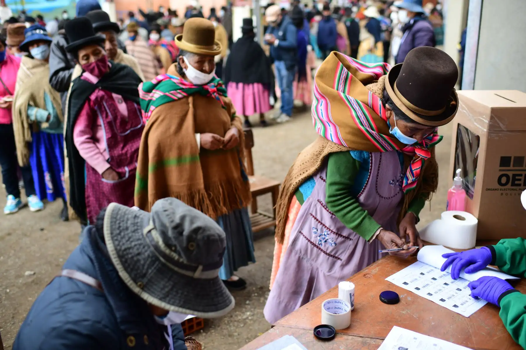 Una mujer indígena firma después de emitir su voto en un colegio electoral en Huarina, Bolivia, durante las elecciones generales que se desarrollan en medio de la pandemia por coronavirus. Foto: AFP