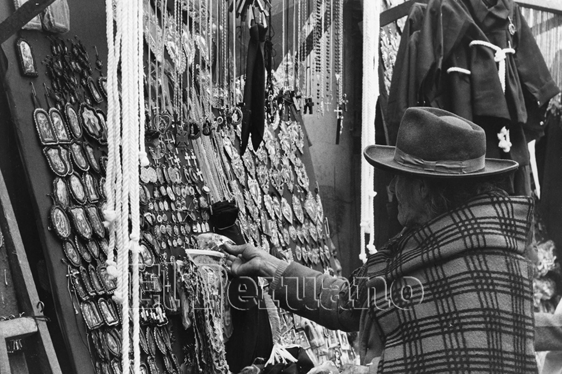 Lima - 4 Octubre 1976. Una anciana observa los detentes o escapularios que  comercializan los ambulantes en las inmediaciones de la Iglesia las Nazarenas en el mes del Señor de los Milagros. Foto: Archivo Histórico de El Peruano / Rolando Ángeles