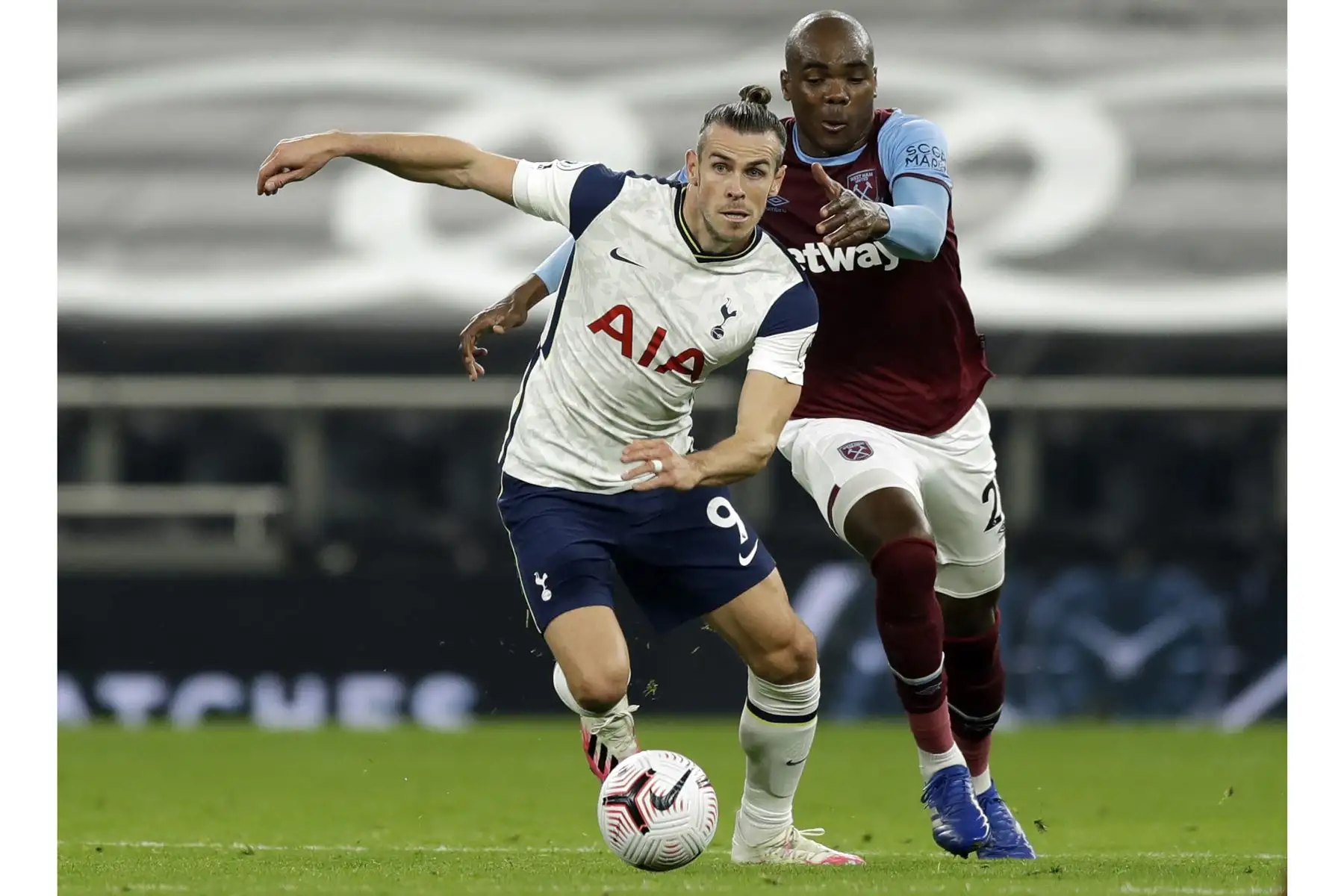 El delantero galés del Tottenham Hotspur Gareth Bale y el defensor italiano del West Ham United, Angelo Ogbonna, compiten por el balón durante el partido de fútbol de la Premier League en el Tottenham Hotspur Stadium de Londres. Foto: AFP