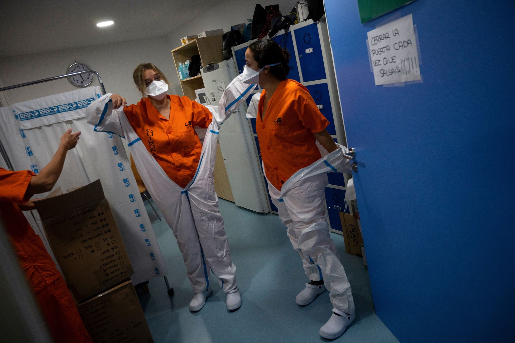 Los trabajadores sanitarios se colocan los trajes de protección antes de atender a los pacientes con coronavirus en la Unidad de Cuidados Intensivos (UCI) del Hospital Universitario Severo Ochoa de Leganés, en Madrid. Foto: AFP