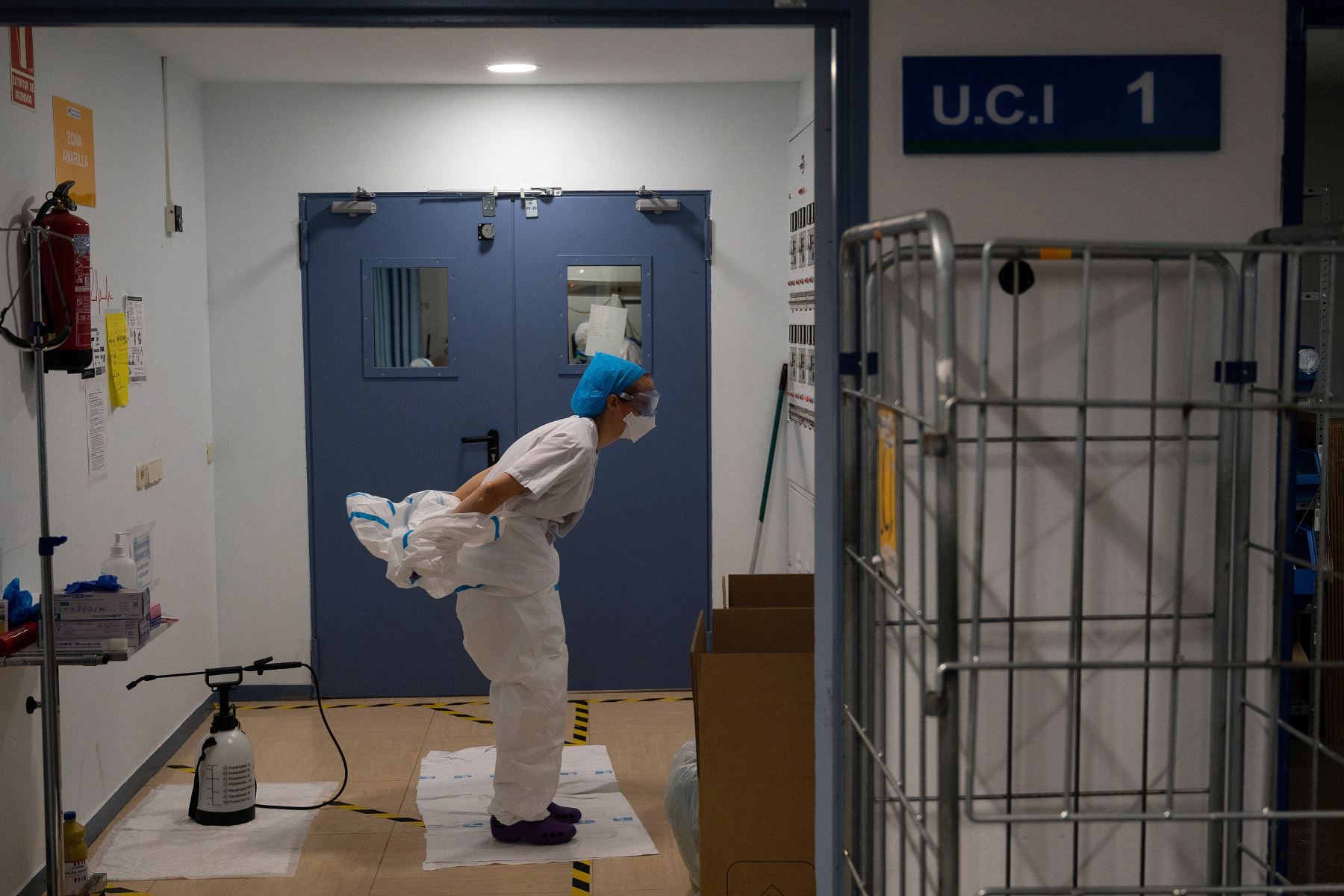 Una trabajadora sanitaria se quita el traje de protección luego de atender a pacientes con coronavirus en la Unidad de Cuidados Intensivos (UCI) del Hospital Universitario Severo Ochoa de Leganés, en Madrid. Foto: AFP