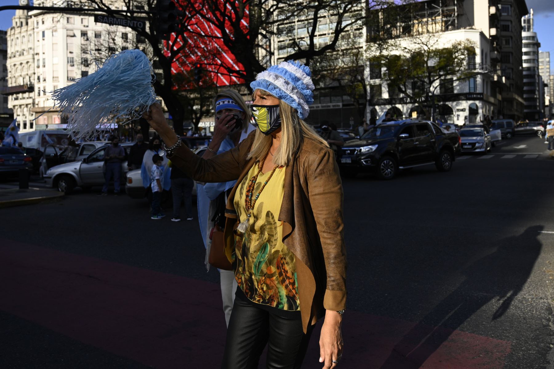 Dos mujeres con mascarillas participan en una protesta contra el gobierno, en la Plaza de la República de Buenos Aires, en medio de la pandemia por coronavirus. Foto: AFP