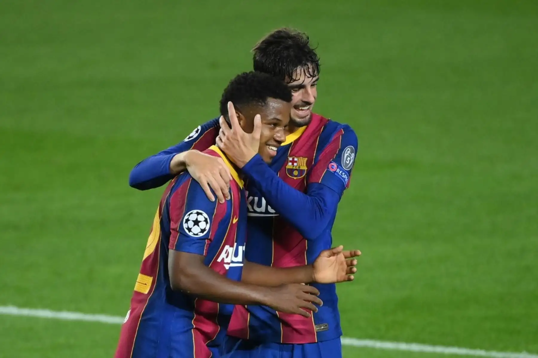 El delantero español del Barcelona Ansu Fati celebra con el delantero portugués del Barcelona Francisco Trincao después de marcar un gol durante el partido de fútbol de la UEFA Champions League entre el FC Barcelona y el Ferencvarosi TC en el estadio Camp Nou de Barcelona. Foto: AFP