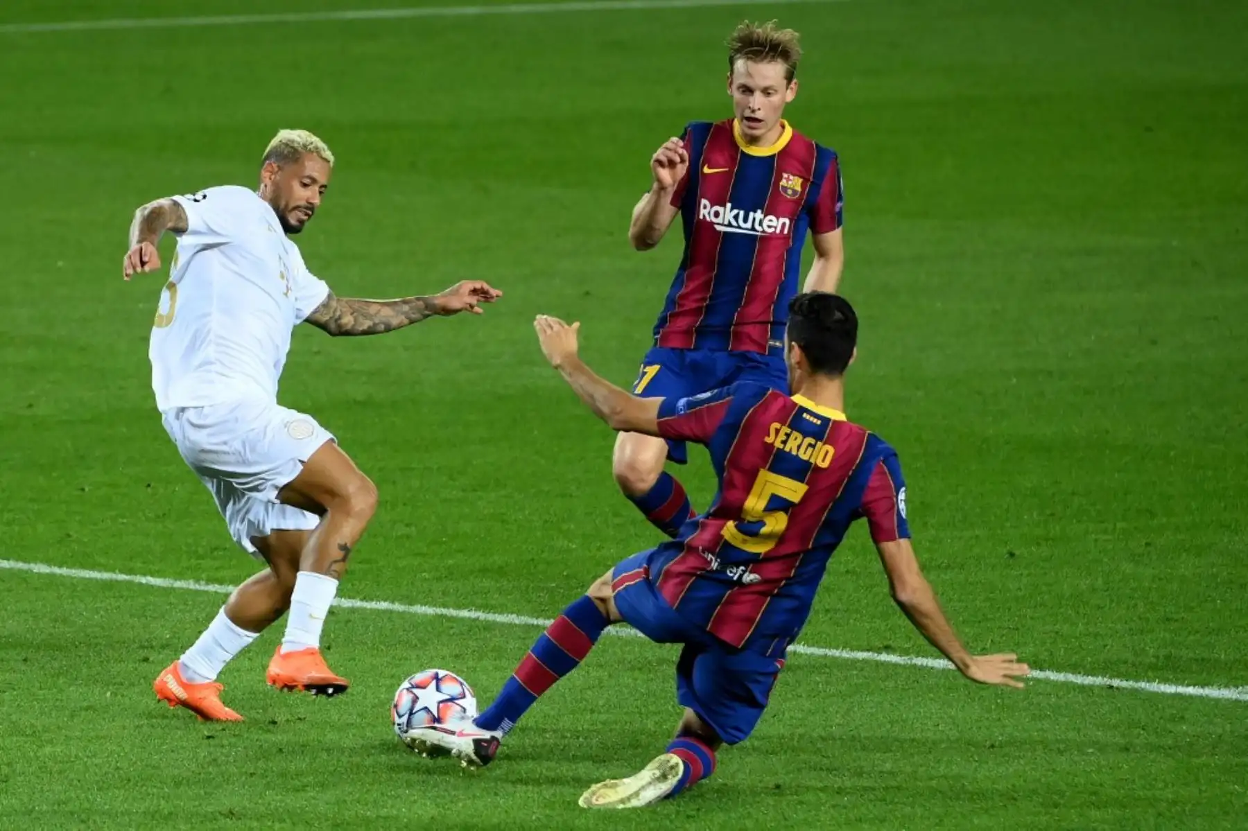 El centrocampista español del Barcelona Sergio Busquets (R) y el centrocampista holandés del Barcelona Frenkie De Jong desafían al mediocampista brasileño del Ferencvaros Isael Barbosa durante el partido de fútbol de la UEFA Champions League entre el FC Barcelona y el Ferencvarosi TC en el estadio Camp Nou de Barcelona. Foto: AFP