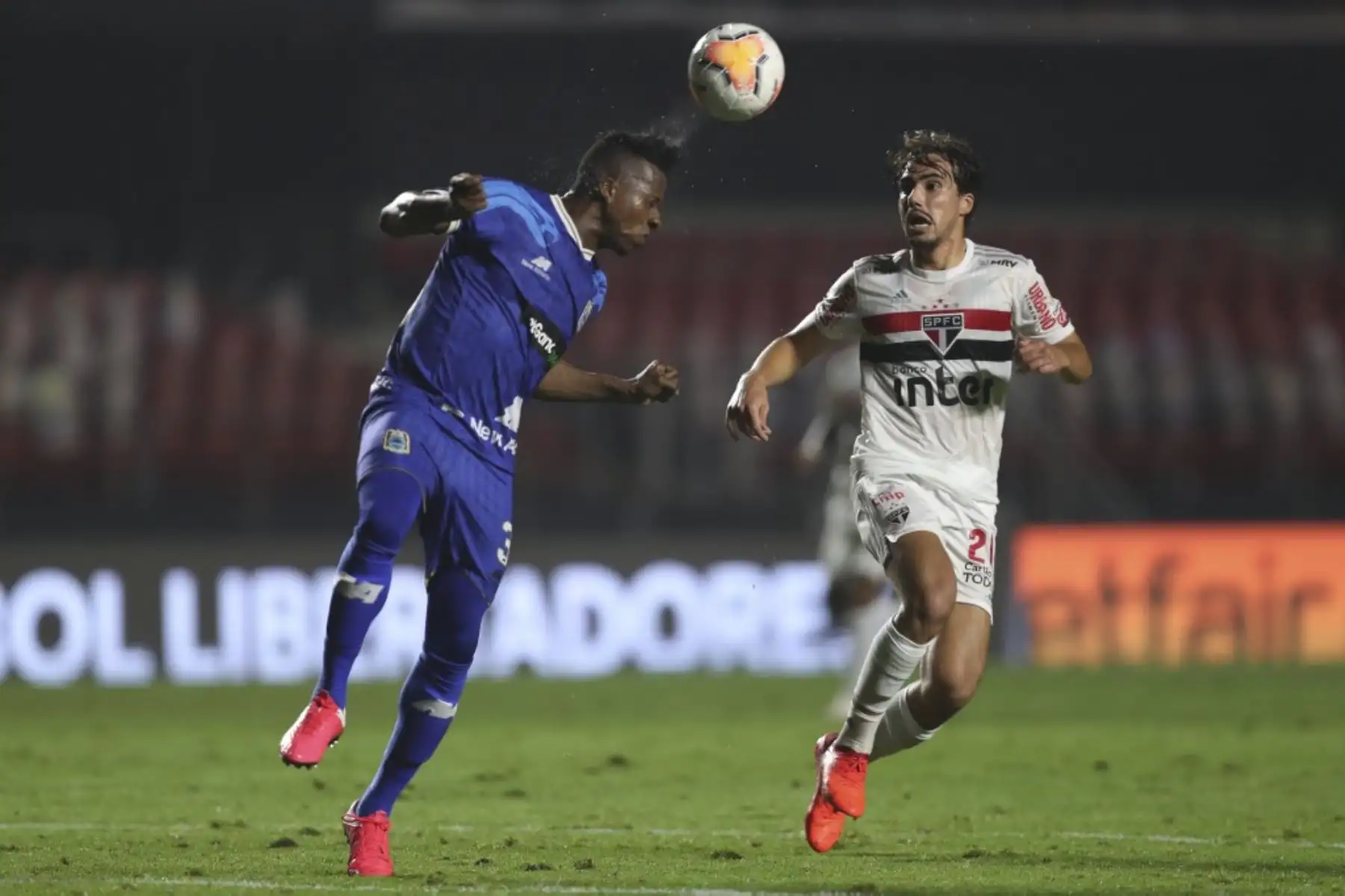El defensor binacional de Perú Camilo Mancilla (L) cabecea el balón sobre el mediocampista del Atlético Paranaense de Brasil Erick compite por el balón durante su partido de fútbol a puerta cerrada de la fase de grupos de la Copa Libertadores en el estadio Morumbi en Sao Paulo, Brasil. Foto: AFP