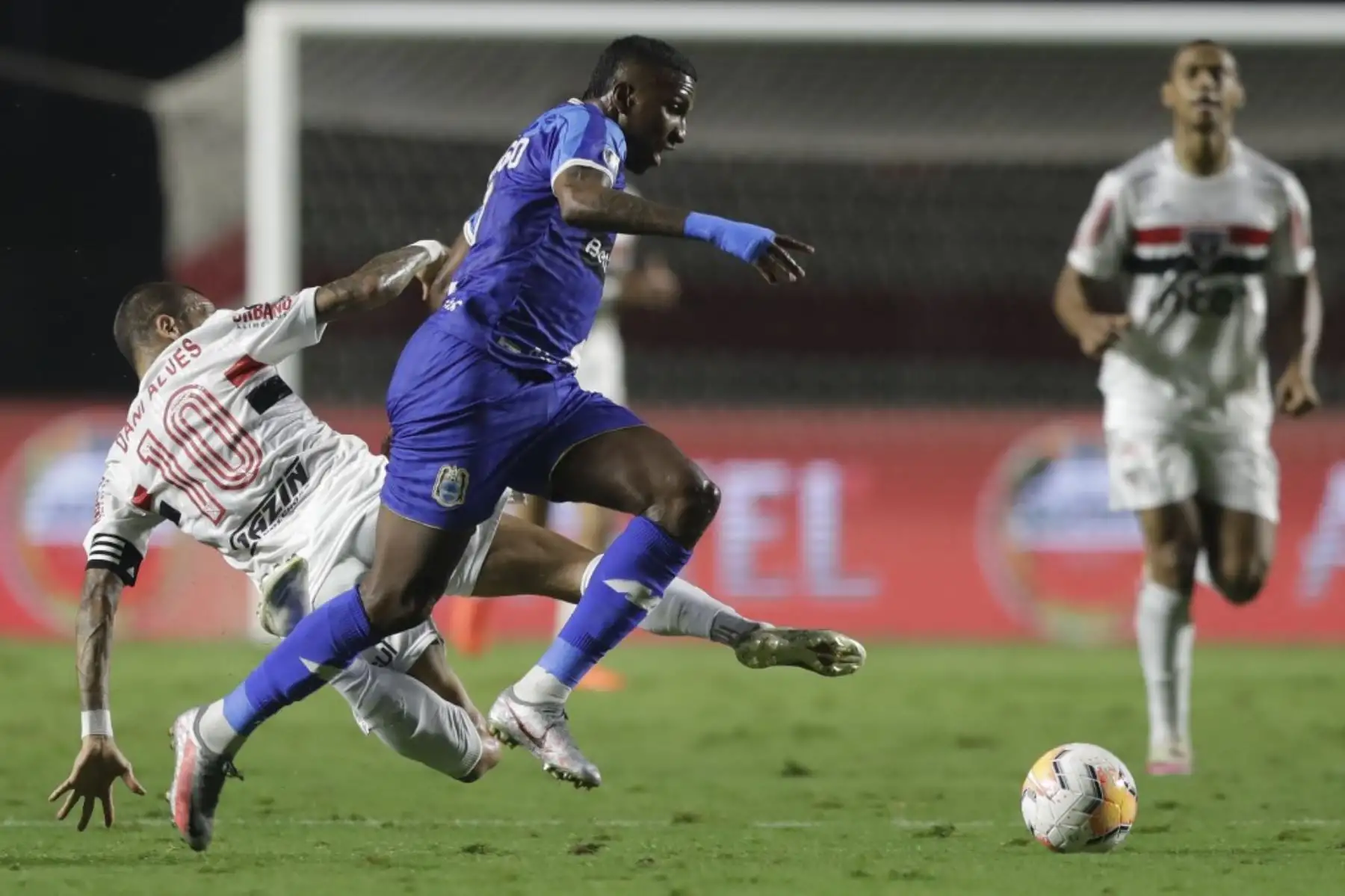 El mediocampista peruano Binacional Johan Arango y el mediocampista brasileño de Sao Paulo Dani Alves compiten por el balón durante su partido de fútbol a puerta cerrada de la fase de grupos de la Copa Libertadores en el estadio Morumbi en Sao Paulo, Brasil. Foto: AFP