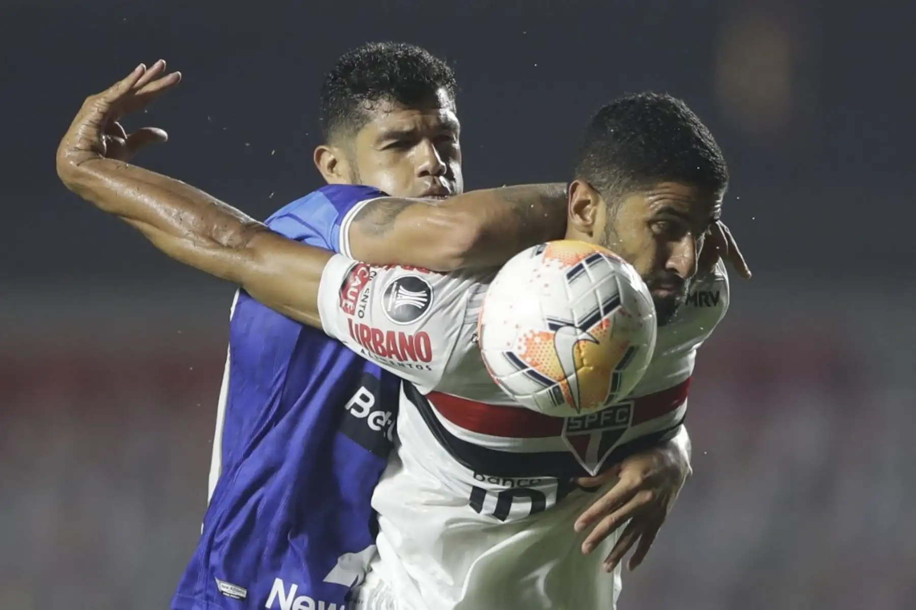 El defensor Binacional de Perú John Fajardo y el delantero brasileño de Sao Paulo, el colombiano Santiago Trellez compiten por el balón durante su partido de fútbol a puerta cerrada en la fase de grupos de la Copa Libertadores en el estadio Morumbi en Sao Paulo, Brasil. Foto: AFP