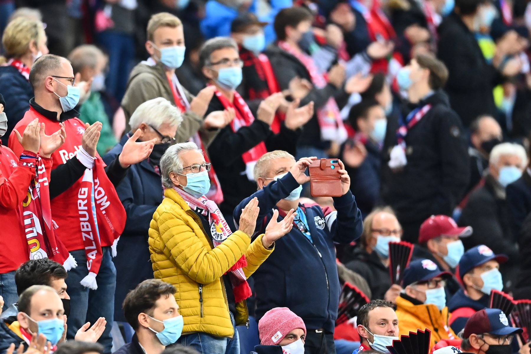 Los fanáticos de Salzburgo usan máscaras mientras observan desde las gradas el partido de fútbol ante Lokomotiv por el Grupo A de la Liga de Campeones de la UEFA. Foto: AFP