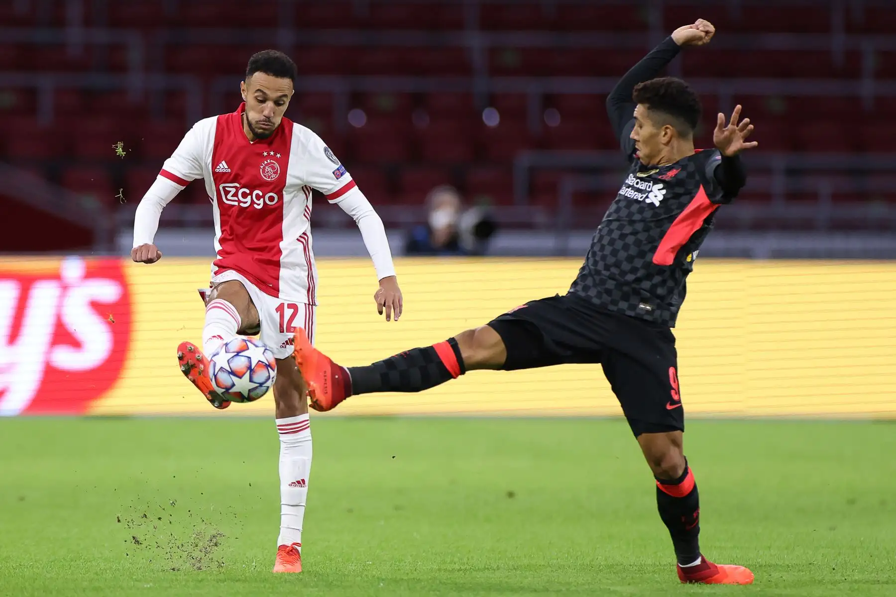 El defensor marroquí del Ajax Noussair Mazraoui compite por el balón con el delantero brasileño del Liverpool, Roberto Firmino, durante el partido de fútbol del Grupo D de la Liga de Campeones de la UEFA. Foto: AFP