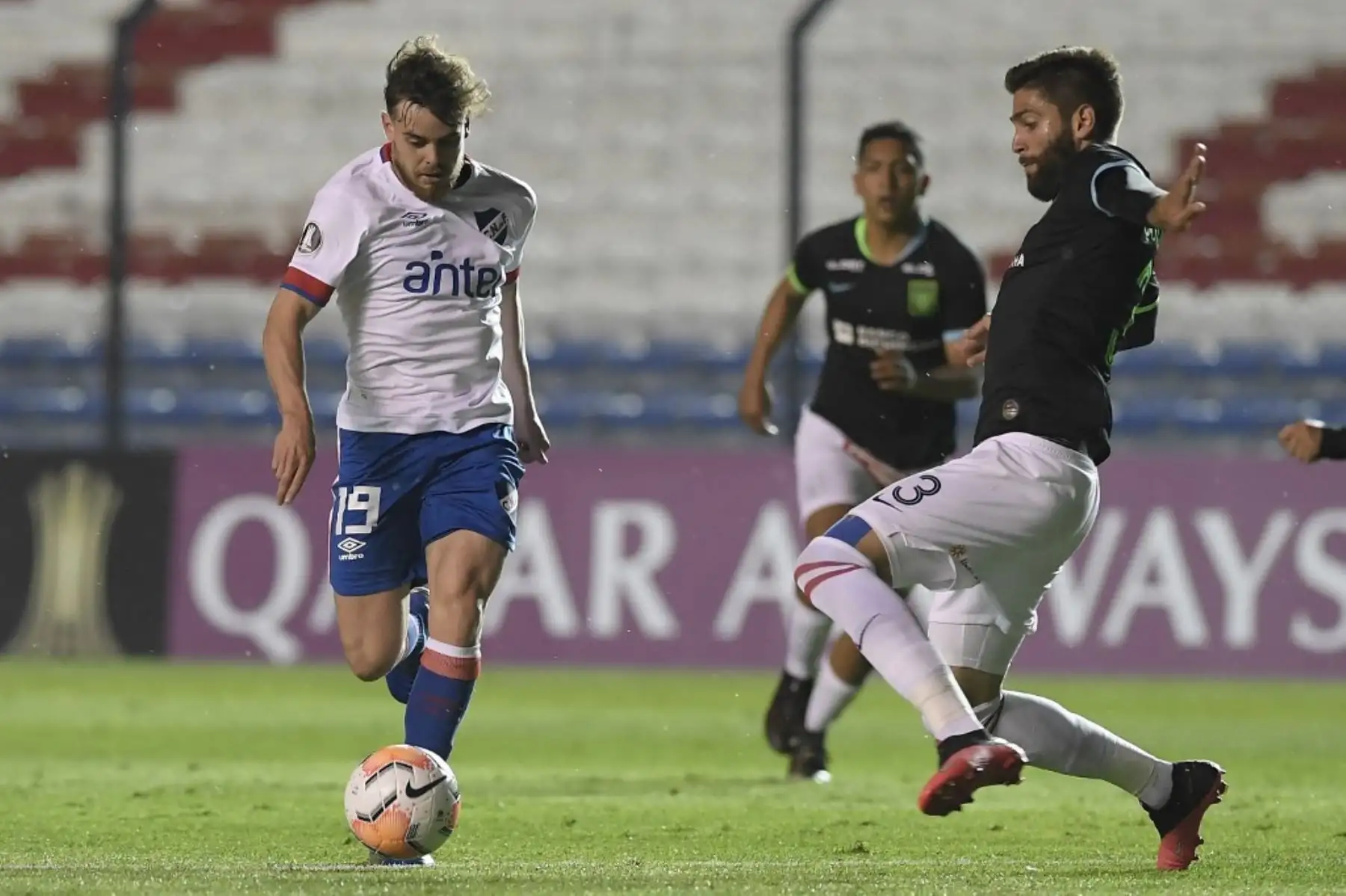 El defensa peruano de Alianza Lima, el venezolano Rubert Quijada y el delantero de la Nacional de Uruguay Alfonso Trezza compiten por el balón durante su partido de fútbol a puerta cerrada en la fase de grupos de la Copa Libertadores en el Estadio Gran Parque Central de Montevideo. Foto: AFP