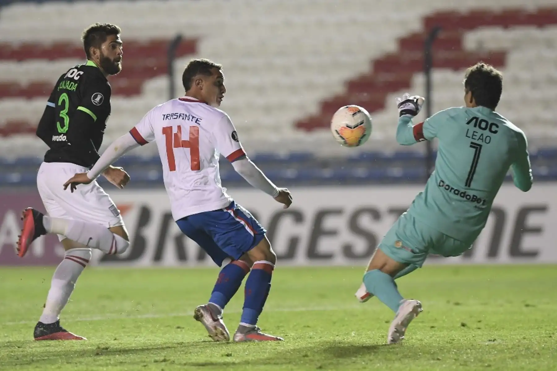 El defensor de Alianza Lima de Perú, el venezolano Rubert Quijada y el mediocampista de Nacional de Uruguay Joaquín Trasante compiten por el balón junto al portero de Alianza Lima de Perú Leao Butrón durante la fase de grupos de la Copa Libertadores a puerta cerrada en el Estadio Gran Parque Central de Montevideo. Foto: AFP