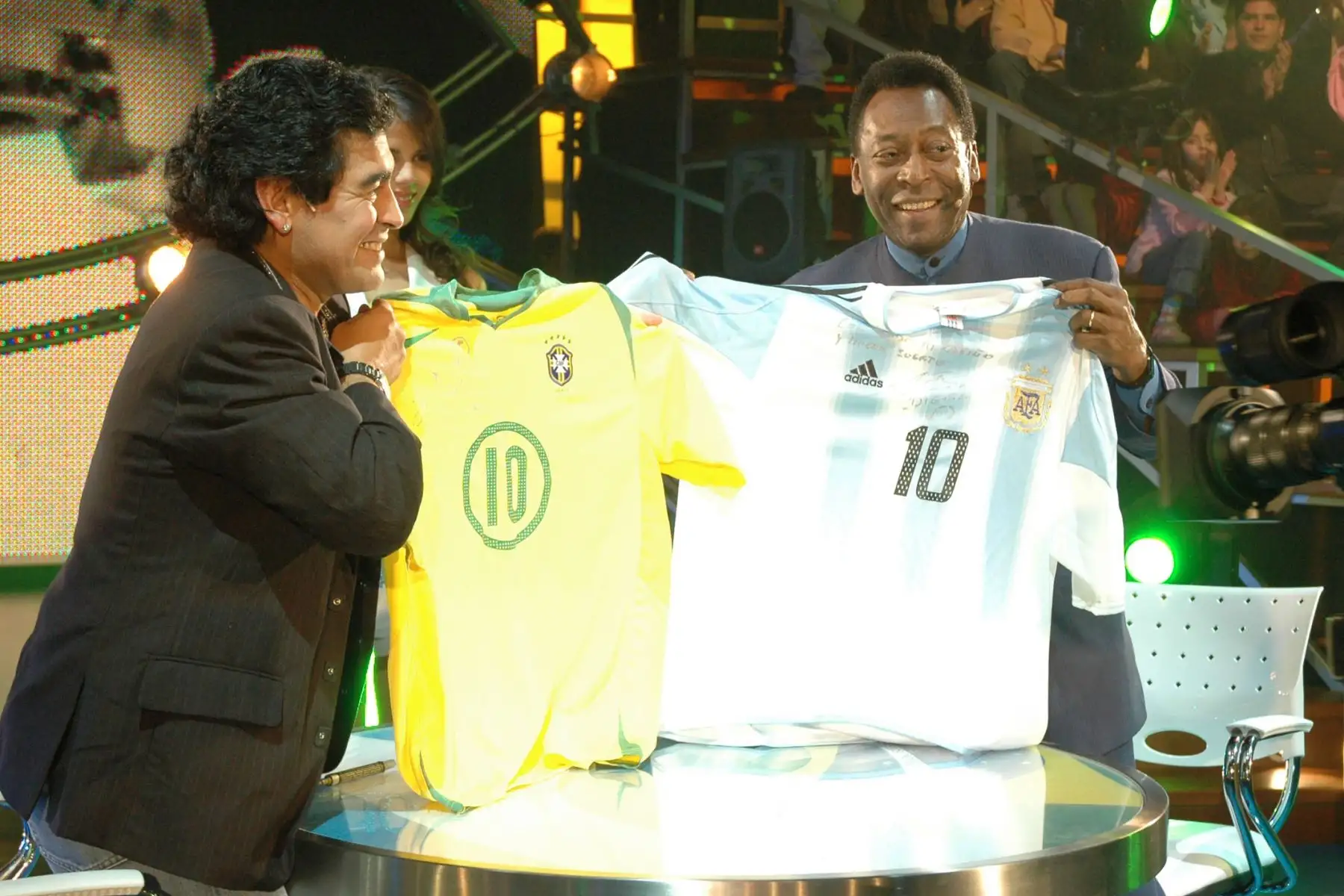 El argentino Diego Maradona muestra una camiseta de la selecciÛn brasileÒa mientras el brasileÒo Edson Arantes do Nascimiento, PelÈ, exhibe una de Argentina, durante el programa "La Noche del 10", cuyo conductor es Maradona, el 15 de agosto de 2005 en Buenos Aires. La prensa brasileÒa calificÛ de "memorable" el encuentro entre los dos mayores astros del f˙tbol de todos los tiempos. Foto: AFP