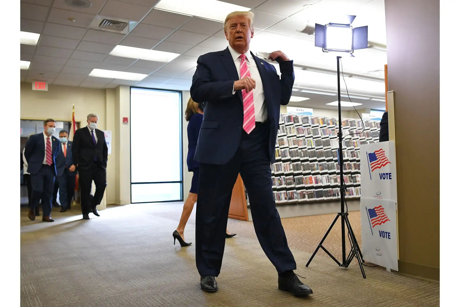 El presidente de los Estados Unidos, Donald Trump, se retira la mascarilla tras emitir su voto colegio electoral para emitir su voto en la Biblioteca Pública del Condado de Palm Beach, durante la votación anticipada para las elecciones del 3 de noviembre, en West Palm Beach, Florida. Foto: AFP