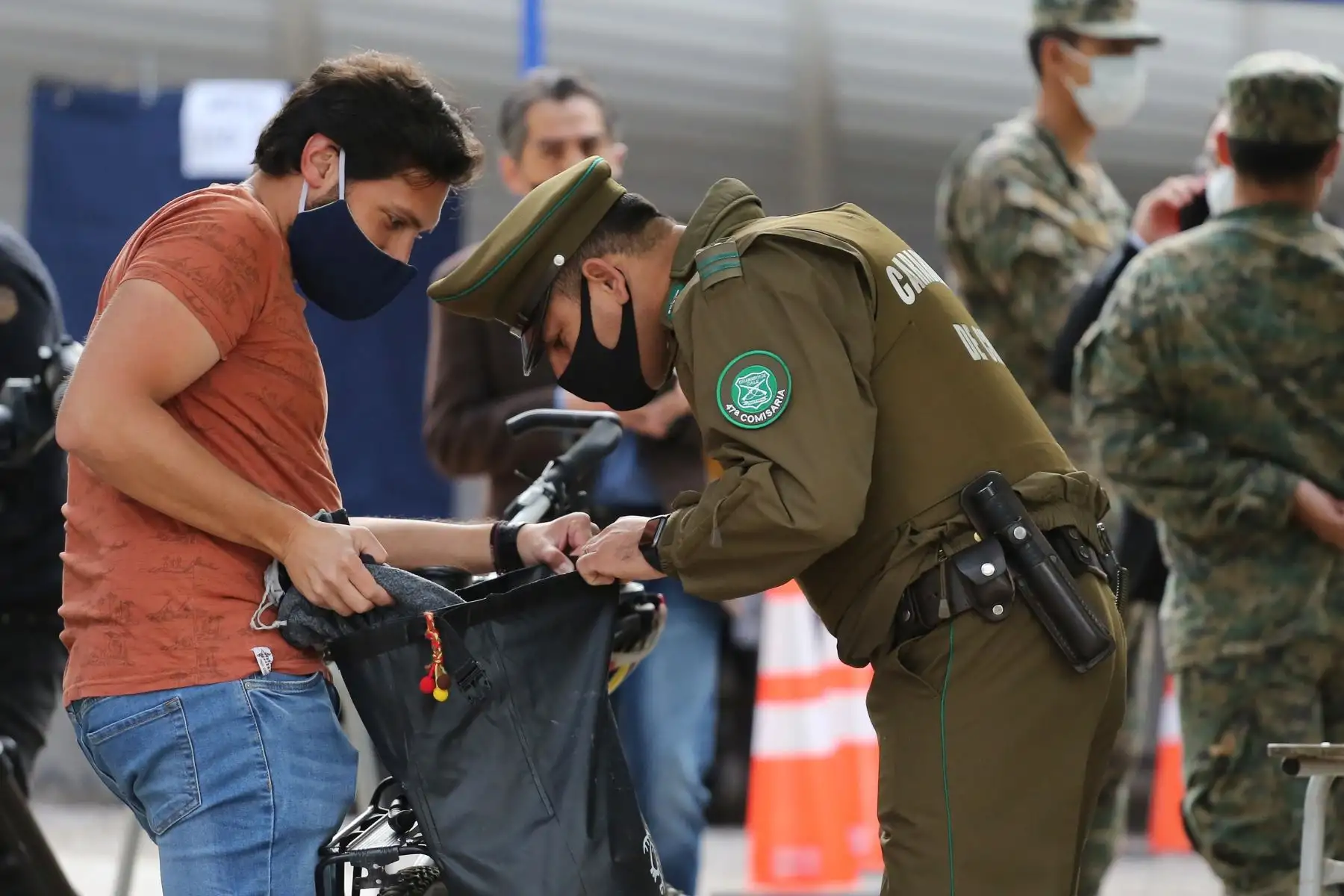 La policía revisa el bolso de un votante en un colegio electoral, este domingo, en Santiago, en Chile. Foto. EFE