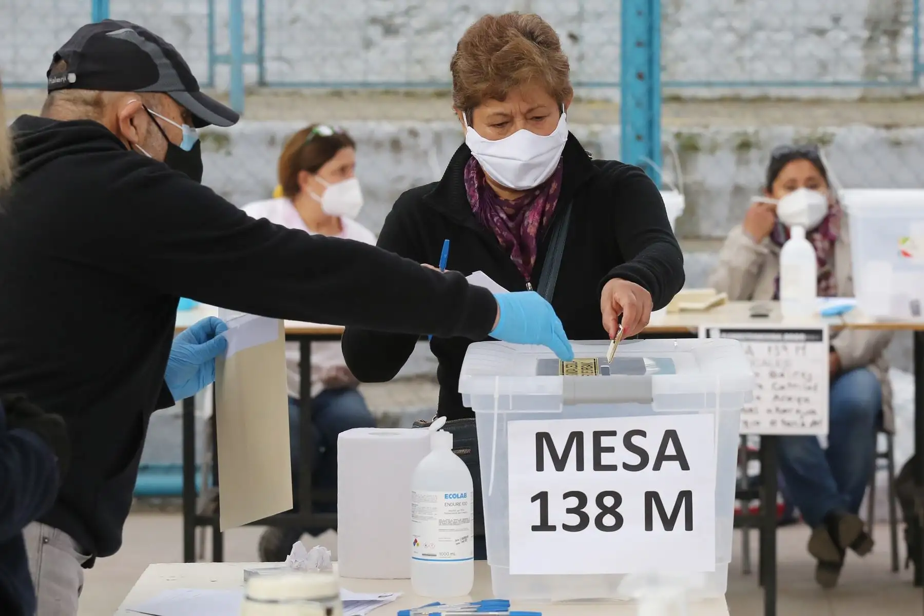 Una mujer ejerce su voto con tapabocas en un colegio electoral, este domingo, en Santiago de Chile. Foto: EFE