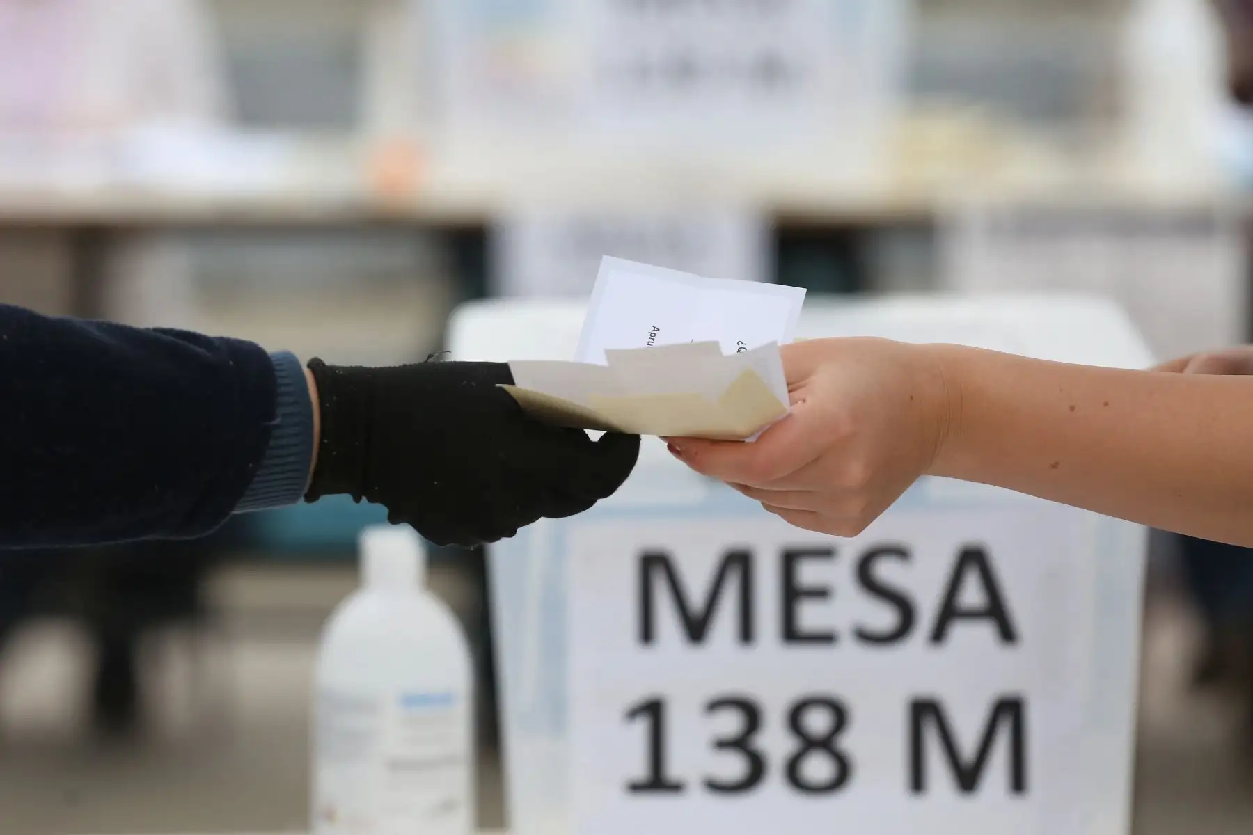 Una mujer recibe papeleta de votación para ejercer su voto en un colegio electoral, este domingo, en Santiago  de Chile. Foto: EFE