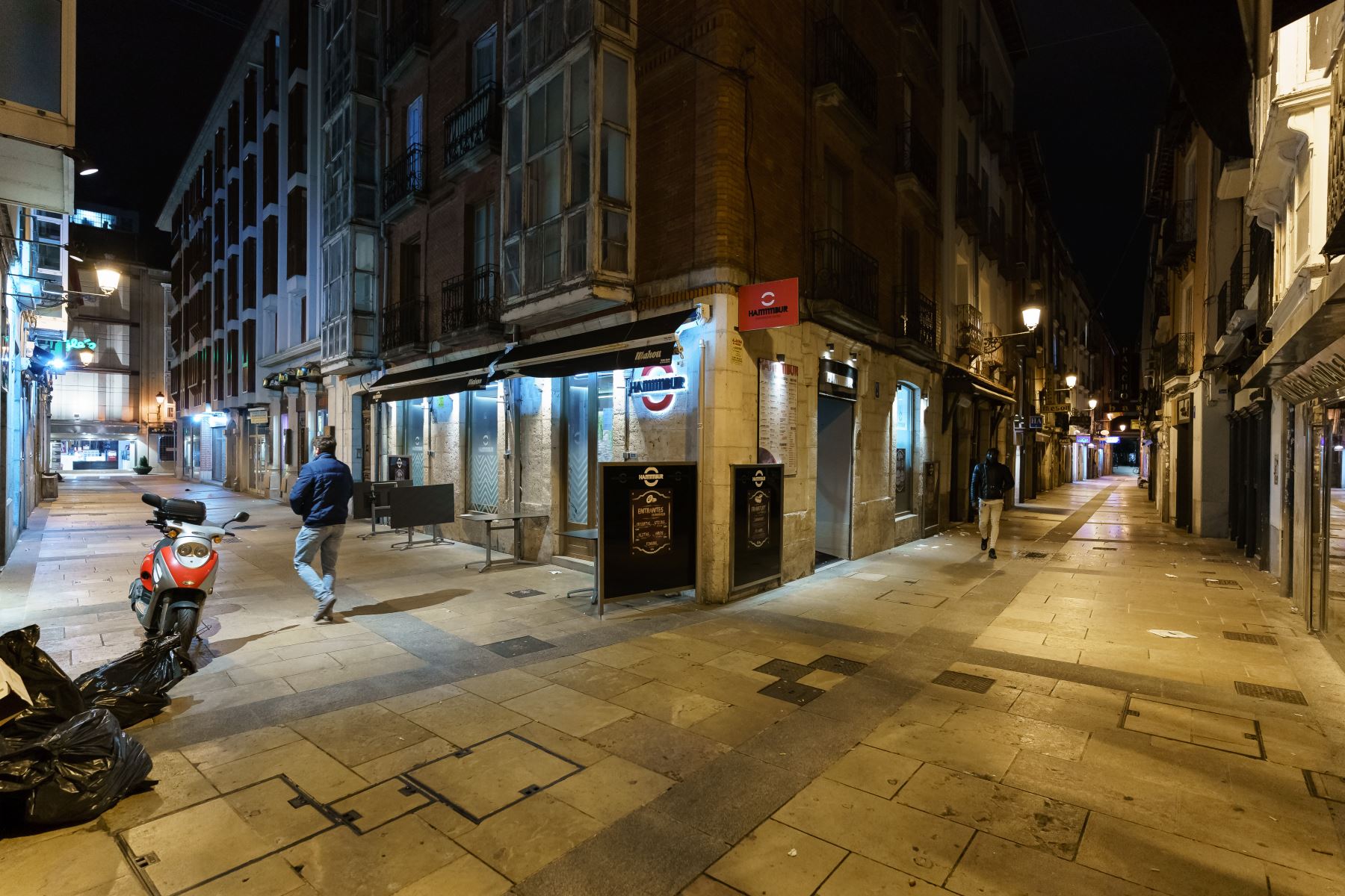 Pocas personas caminan por una calle del centro de Burgos, en la región de Castilla y León, tras la entrada en vigor del toque de queda en la localidad, el 24 de octubre de 2020. Foto: AFP