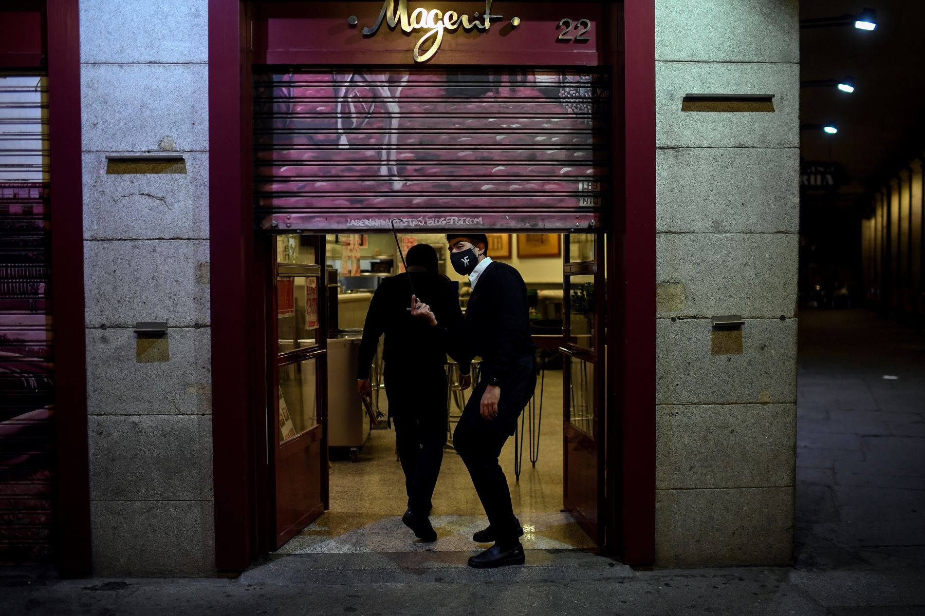 Los empleados se preparan para cerrar un bar al final de un día de trabajo en la Plaza Mayor de Madrid, el 24 de octubre de 2020. Foto: AFP