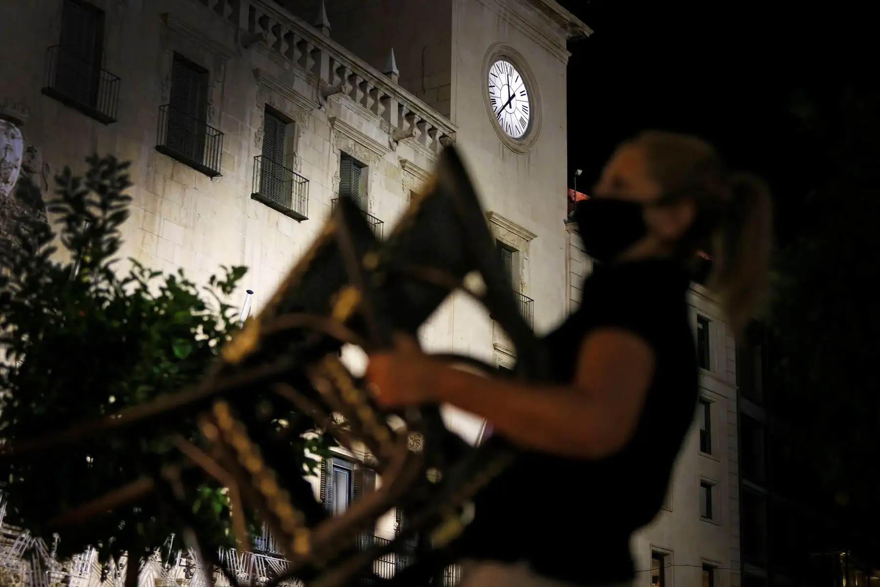 Una trabajadora de hostelería recoge su terraza en Alicante antes del toque de queda que comienza hoy sábado en la Comunidad Valenciana. Foto: EFE