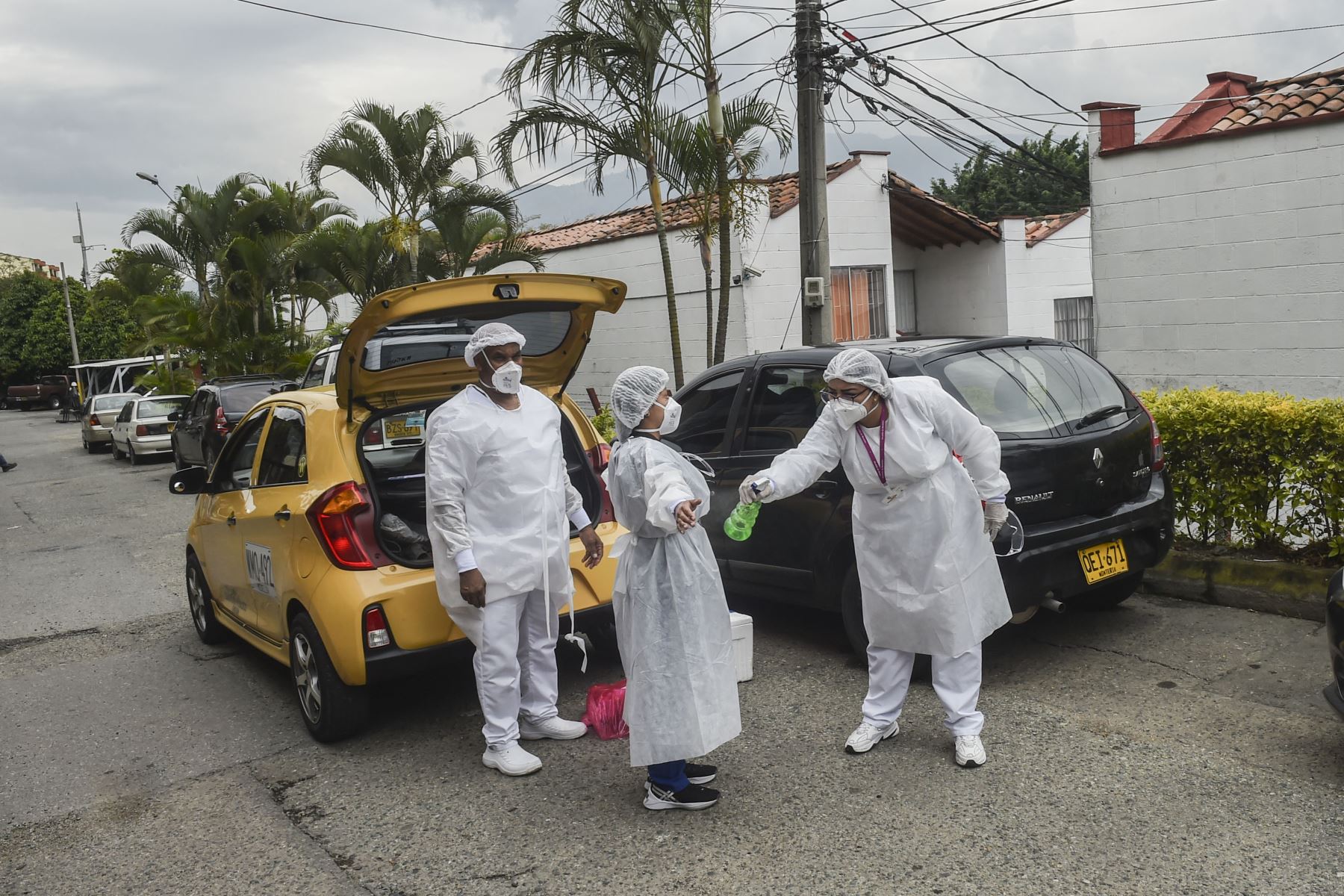 Los trabajadores de salud se desinfectan entre sí después de tomar muestras de sangre durante un estudio de prueba de seroprevalencia Covid-19 en Medellín, Colombia. Foto: AFP