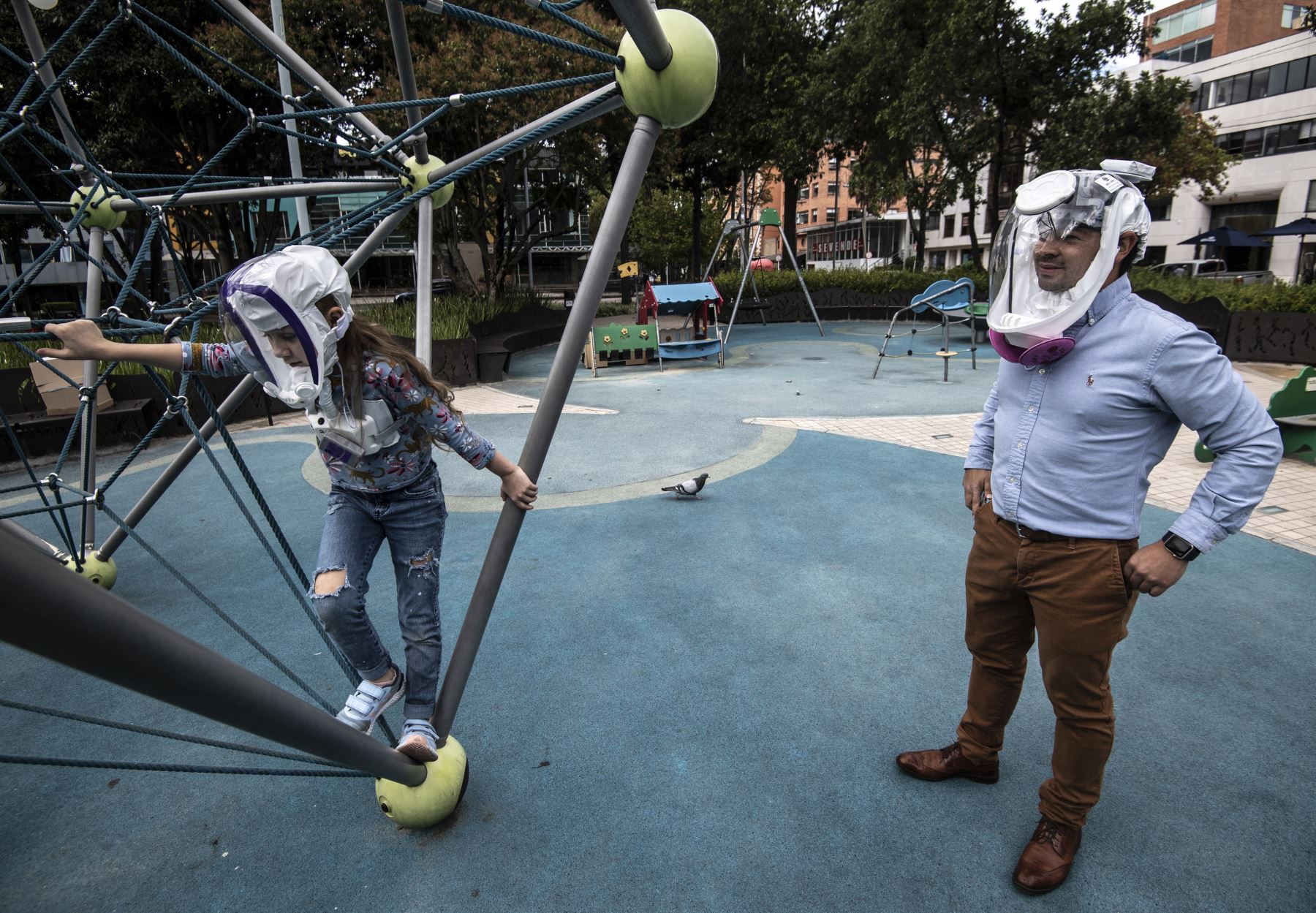 Un hombre y su hija usan máscaras de ventilación para protegerse del coronavirus en un parque de Bogotá, en Colombia. Foto: AFP