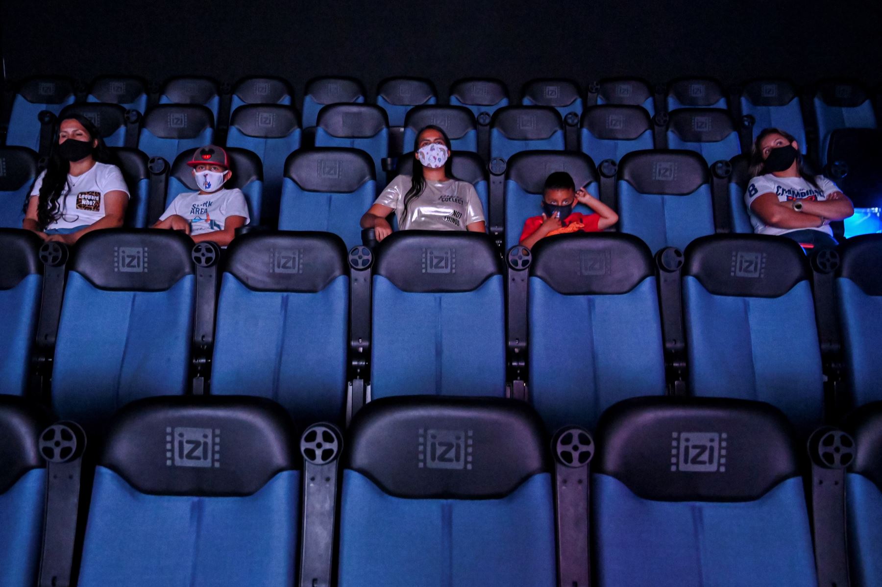 La gente disfruta de una película en el cine que reabrió sus puertas luego de la facilidad de las medidas impuestas por el gobierno colombiano, en Cali. Foto: AFP