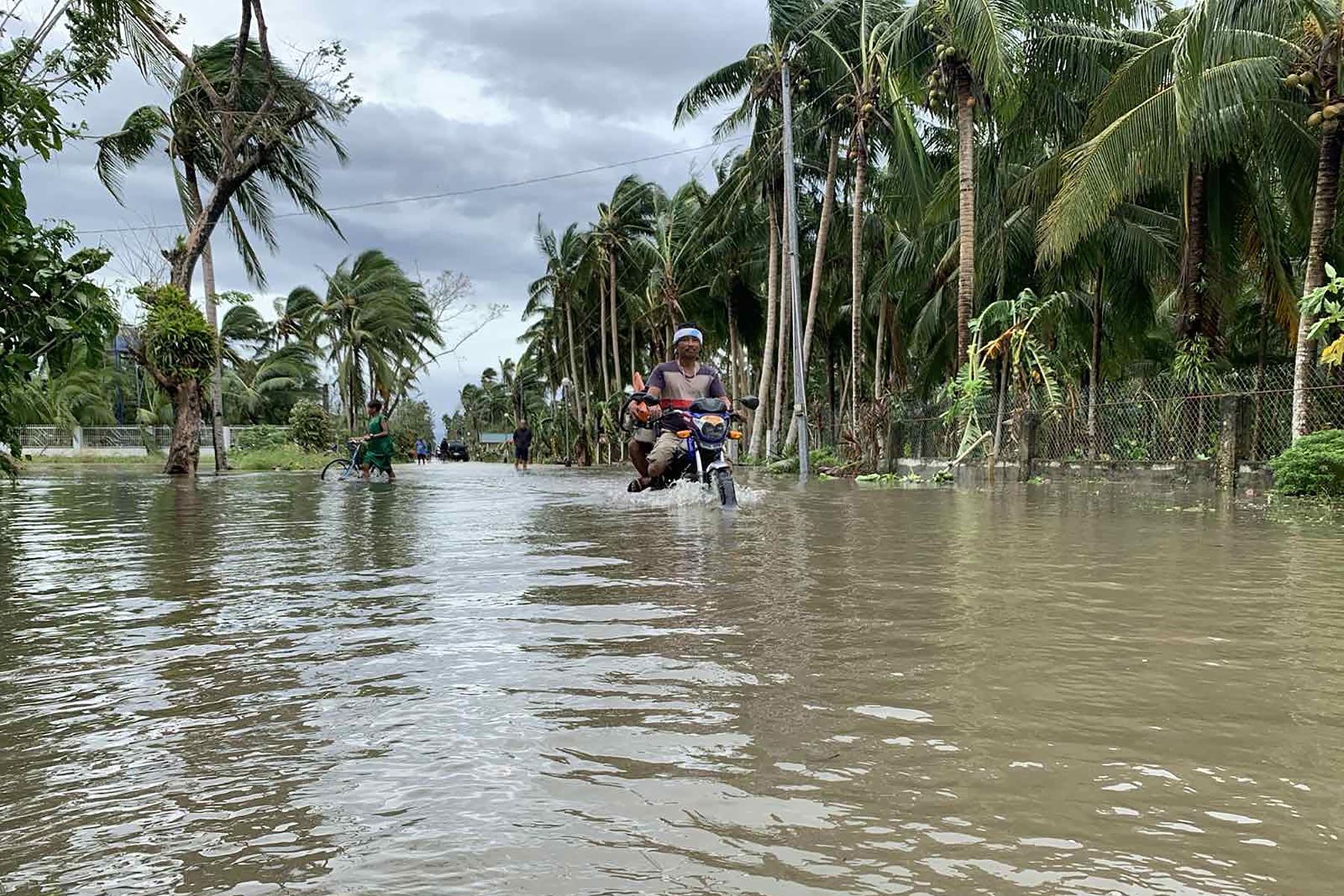 Un motociclista atraviesa una calle inundada después de que el tifón Molave ​​azotara la ciudad de Pola, provincia de Mindoro Oriental, en Filipinas. Foto: AFP
