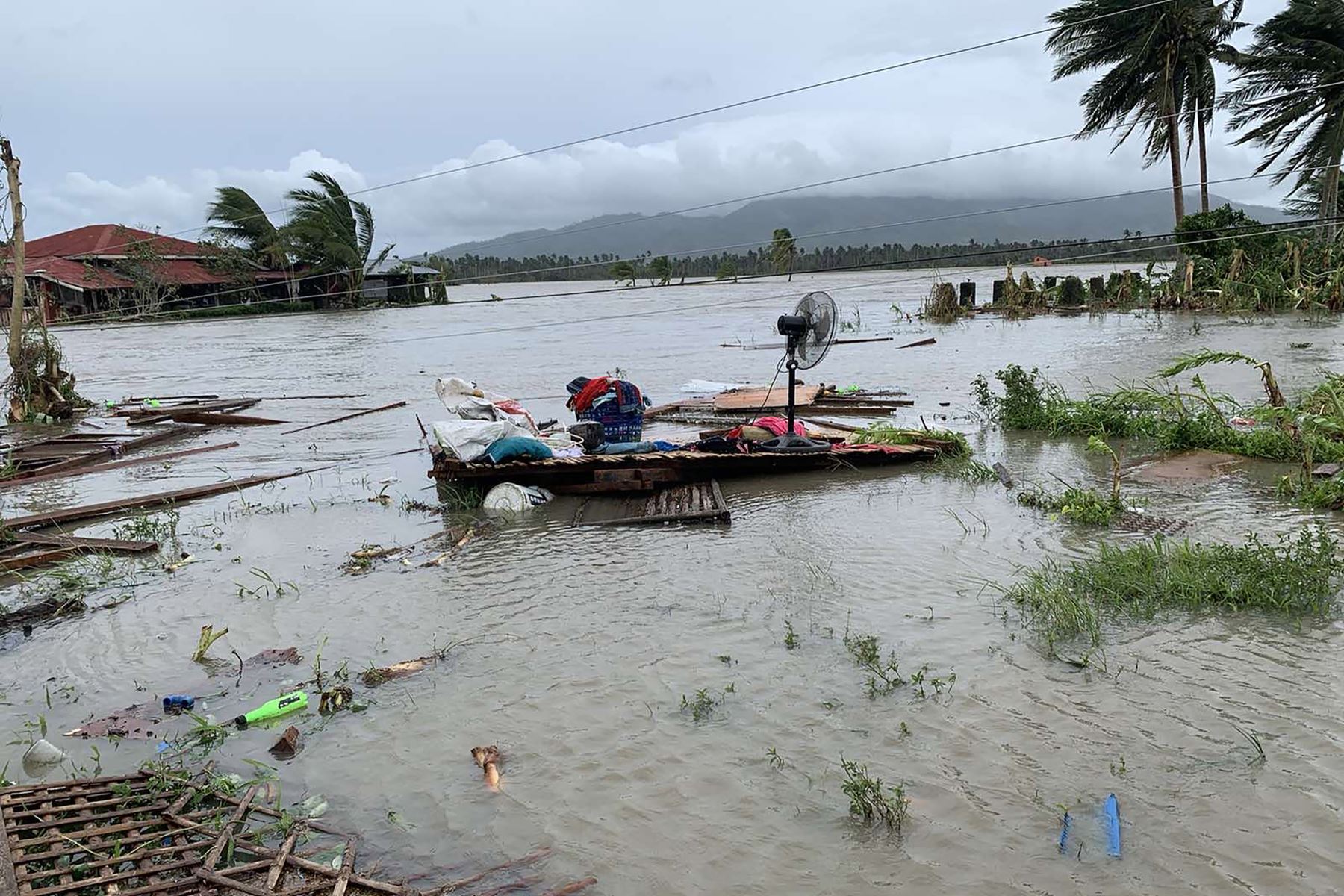 Un ventilador eléctrico y otras pertenencias flotan en una zona inundada luego que tormenta tropical Molave ​​azotara la ciudad de Pola, provincia de Mindoro Oriental, en Filipinas. Foto: AFP