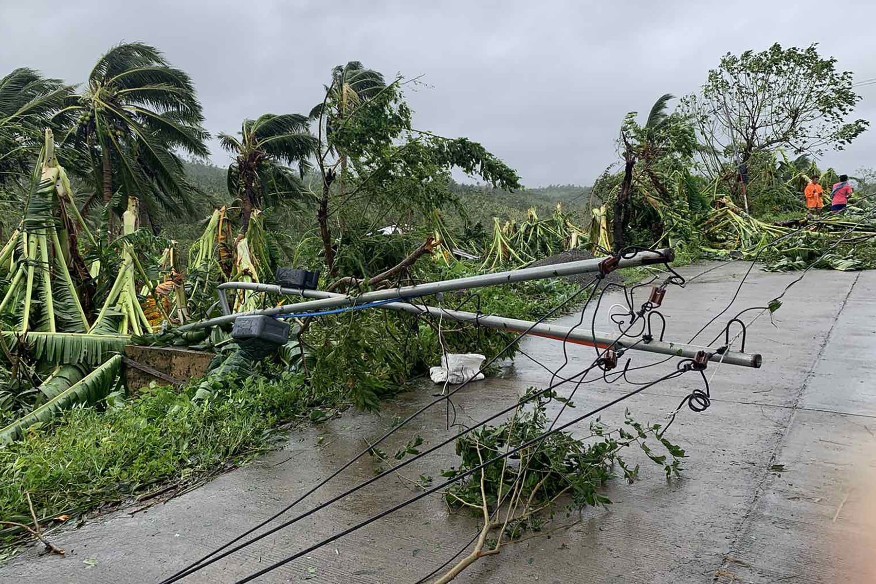 Un poste eléctrico caído bloquea la carretera después que la tormenta tropical Molave ​​azotara la ciudad de Pola, provincia de Mindoro Oriental, en Filipinas. Foto. AFP