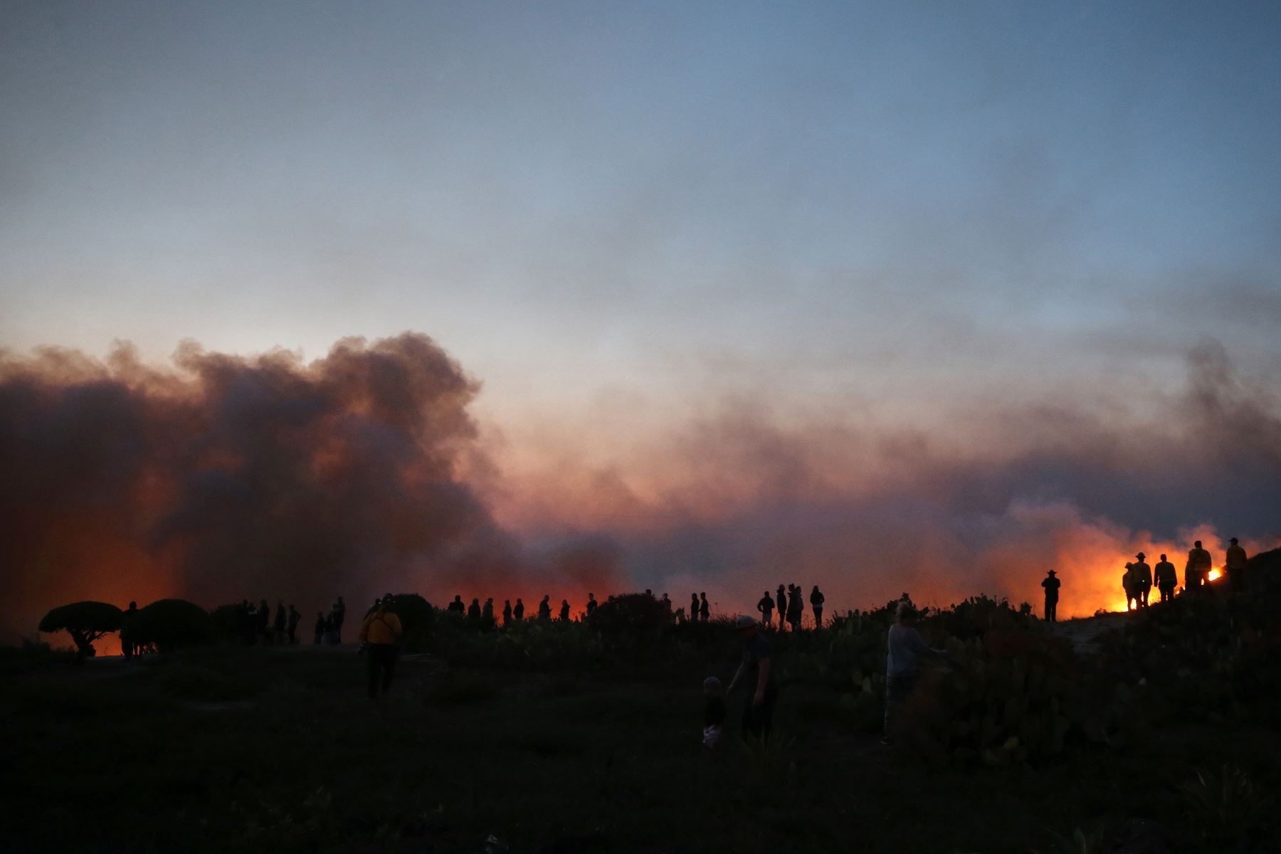 Las personas observan el incendio en un cañón en el condado de Orange, en Lake Forest, California. Foto: AFP
