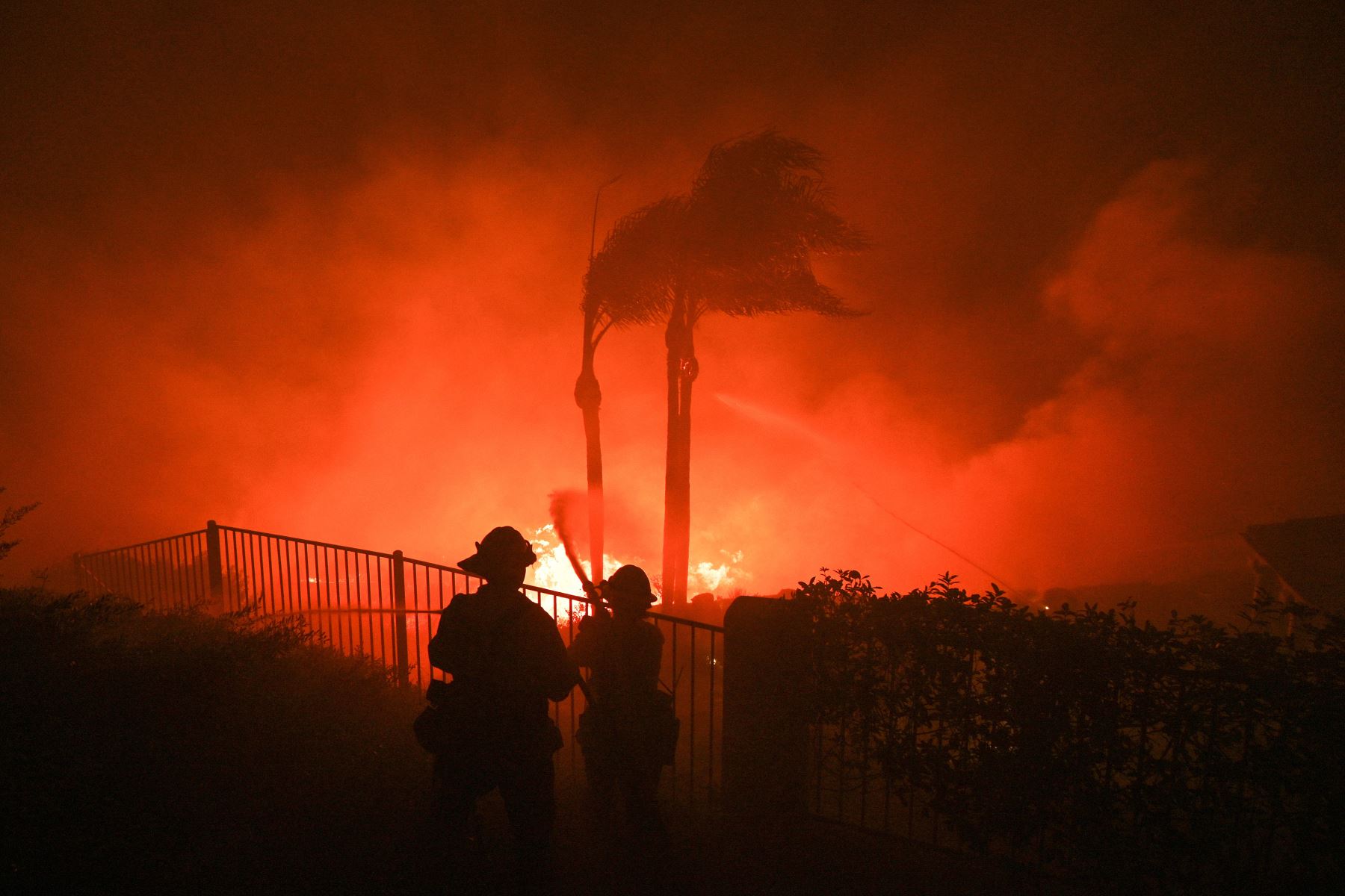 Los bomberos intentan sofocar las llamas del patio de una casa en el incendio Blue Ridge en Yorba Linda, California. Foto: AFP