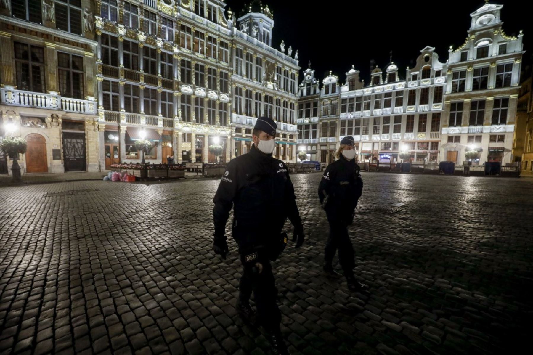 Agentes de policía con máscaras protectoras patrullan al inicio del toque de queda en Bruselas el como medida contra la propagación de la pandemia COVID-19 causada por el nuevo coronavirus. Foto: AFP