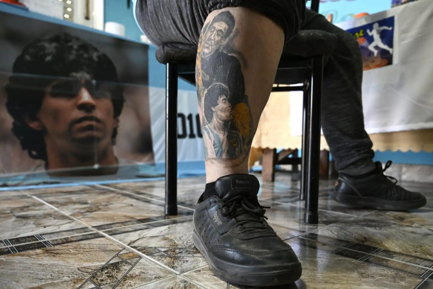 El pizzero Guillermo Rodríguez, bautizado en la iglesia Maradoniana, muestra los tatuajes en su espalda que representan a la leyenda del fútbol argentino Diego Maradona, en su pizzería llamada "Siempre al 10" (Siempre al 10), en referencia al número de la ex camiseta de su ídolo. , en Merlo, provincia de Buenos Aires. Rodríguez se hizo este tatuaje para conmemorar el 60 cumpleaños del actual entrenador de Gimnasia y Esgrima, que será el próximo 30 de octubre.

Foto: AFP