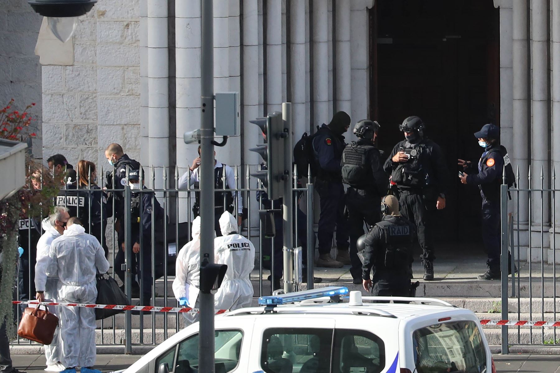 Miembros franceses de la unidad de policía táctica de élite RAID entran para registrar la Basílica de Notre-Dame de Nice mientras los agentes forenses esperan afuera después de un ataque con cuchillo. Foto: AFP