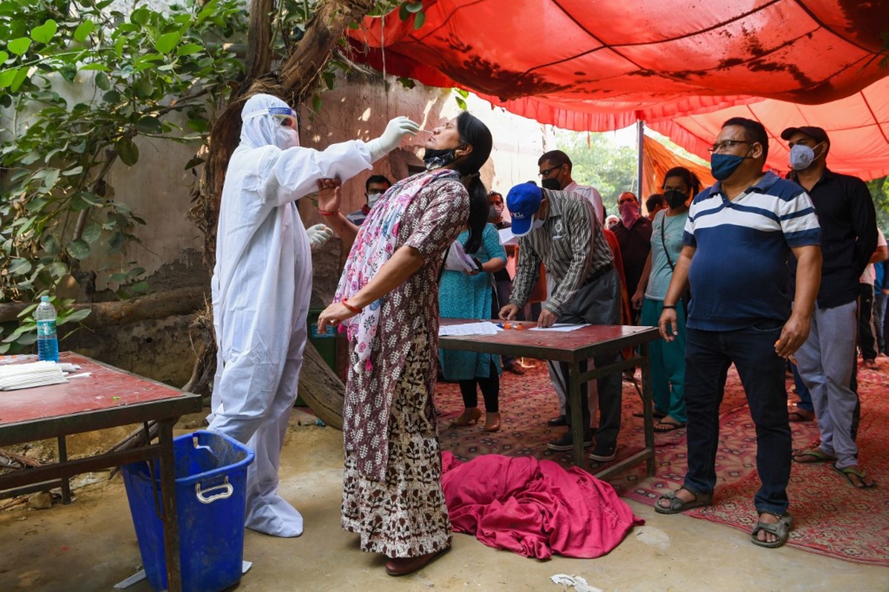 Un trabajador médico toma una muestra de hisopo de una mujer en Ghaziabad. Foto:AFP