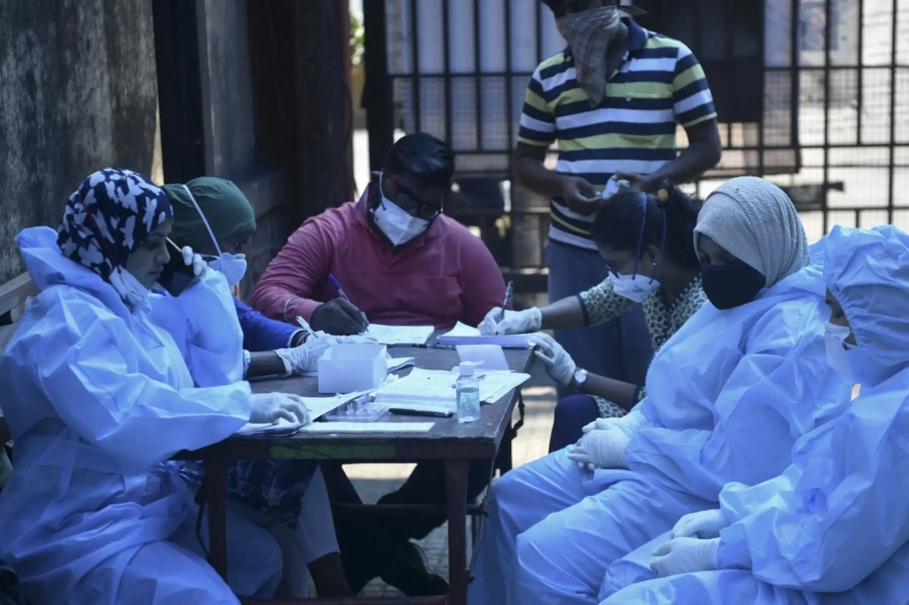 Trabajadores de la salud se preparan para recolectar muestras de hisopos de los residentes para realizar la prueba del covid-19 en el centro de recolección de muestras en Hyderabad.Foto:AFP