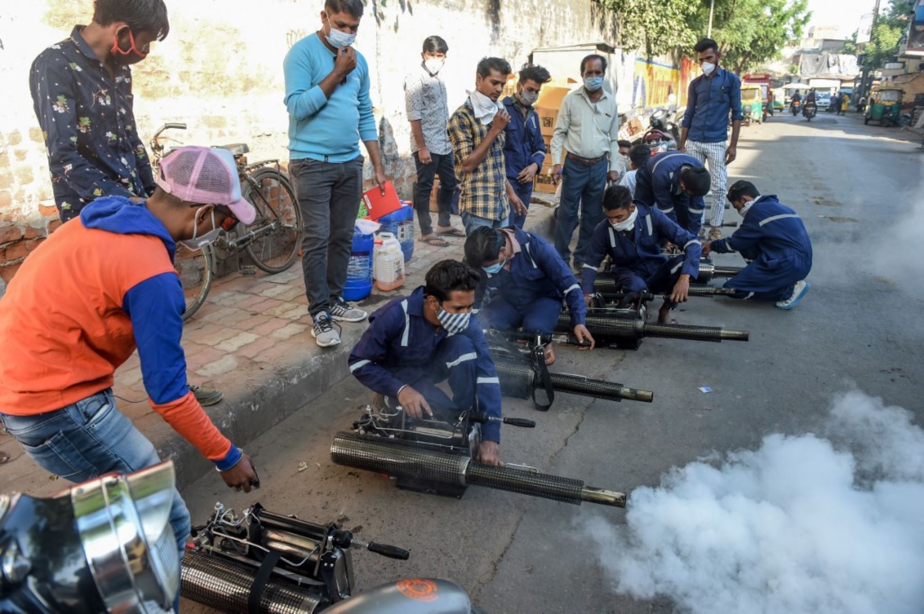 Los trabajadores prueban nuevas máquinas de nebulización térmica utilizadas contra mosquitos y diversas enfermedades, incluido el covid-19, en una calle de Ahmedabad, en la India. Foto:AFP