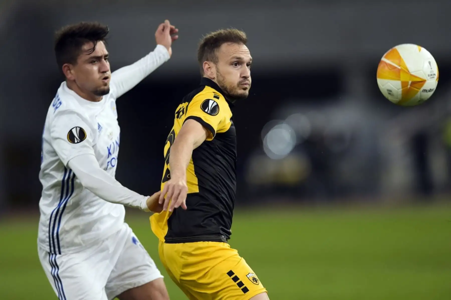 El jugador del AEK de Grecia, Stratos Svarnas, disputa el balón con Jamie Barney del Leicester por la Copa UEFA. Foto: AFP