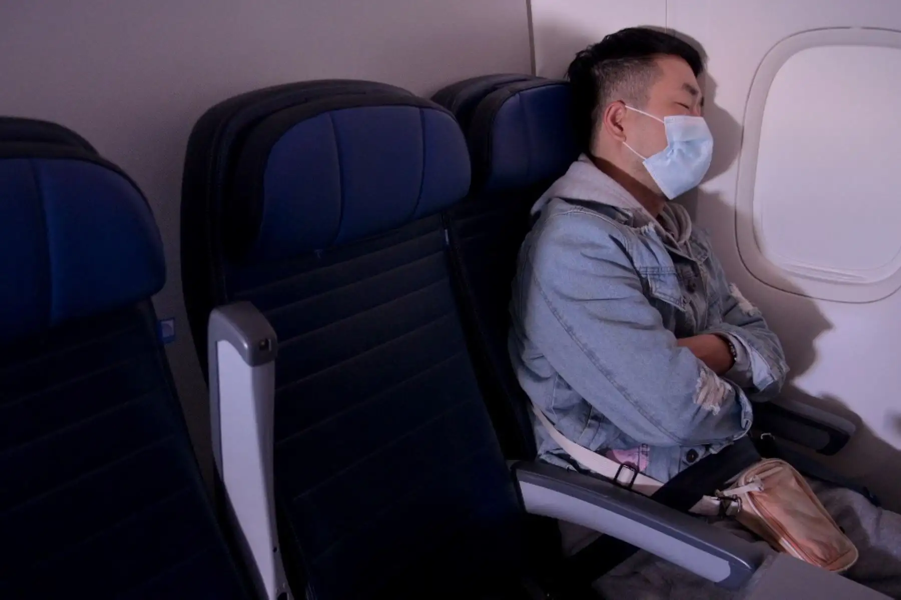 Se ve a un pasajero enmascarado durmiendo en un vuelo de San Francisco, California a Newark, Nueva Jersey. Foto: AFP