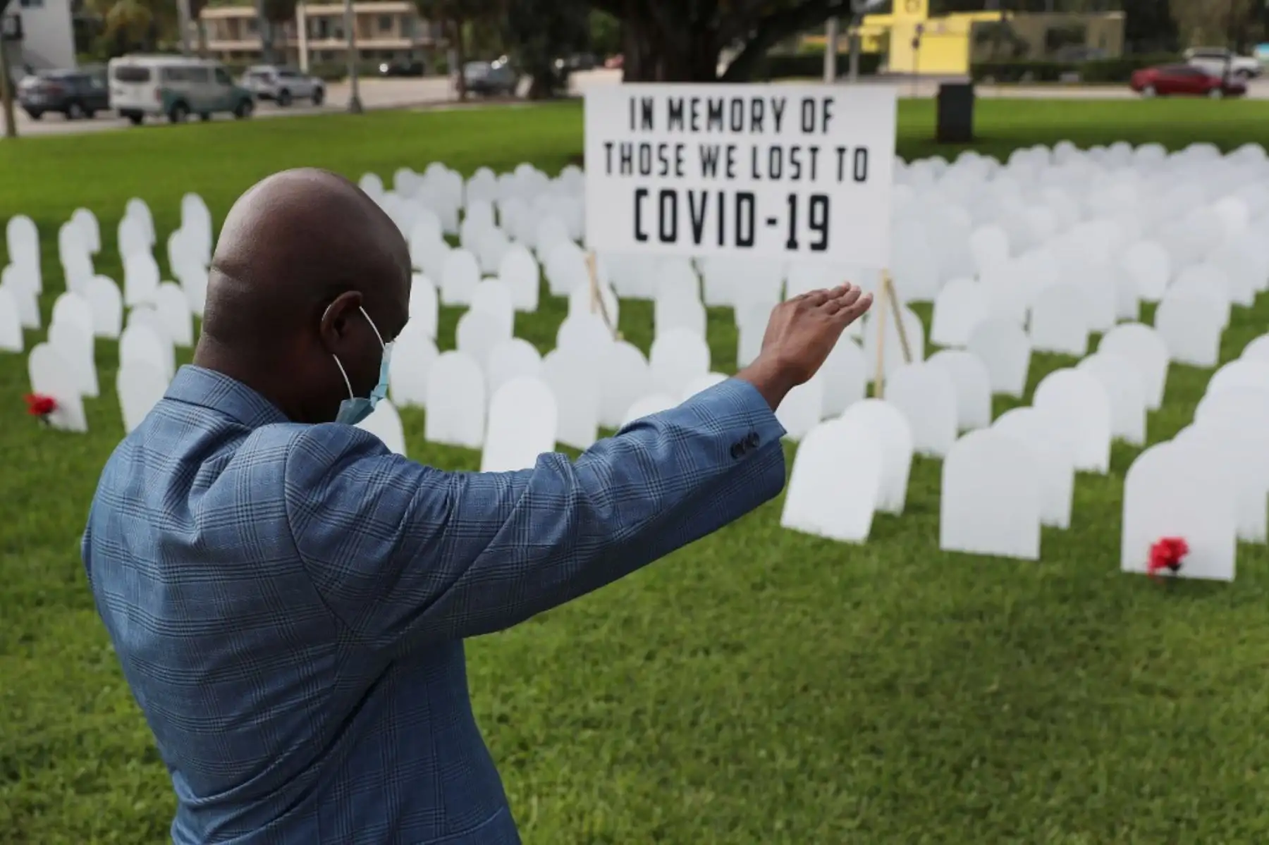 El vicealcalde de North Miami, Alix Desulme, levanta el brazo durante una oración por las vidas perdidas por covid-19. Foto: AFP