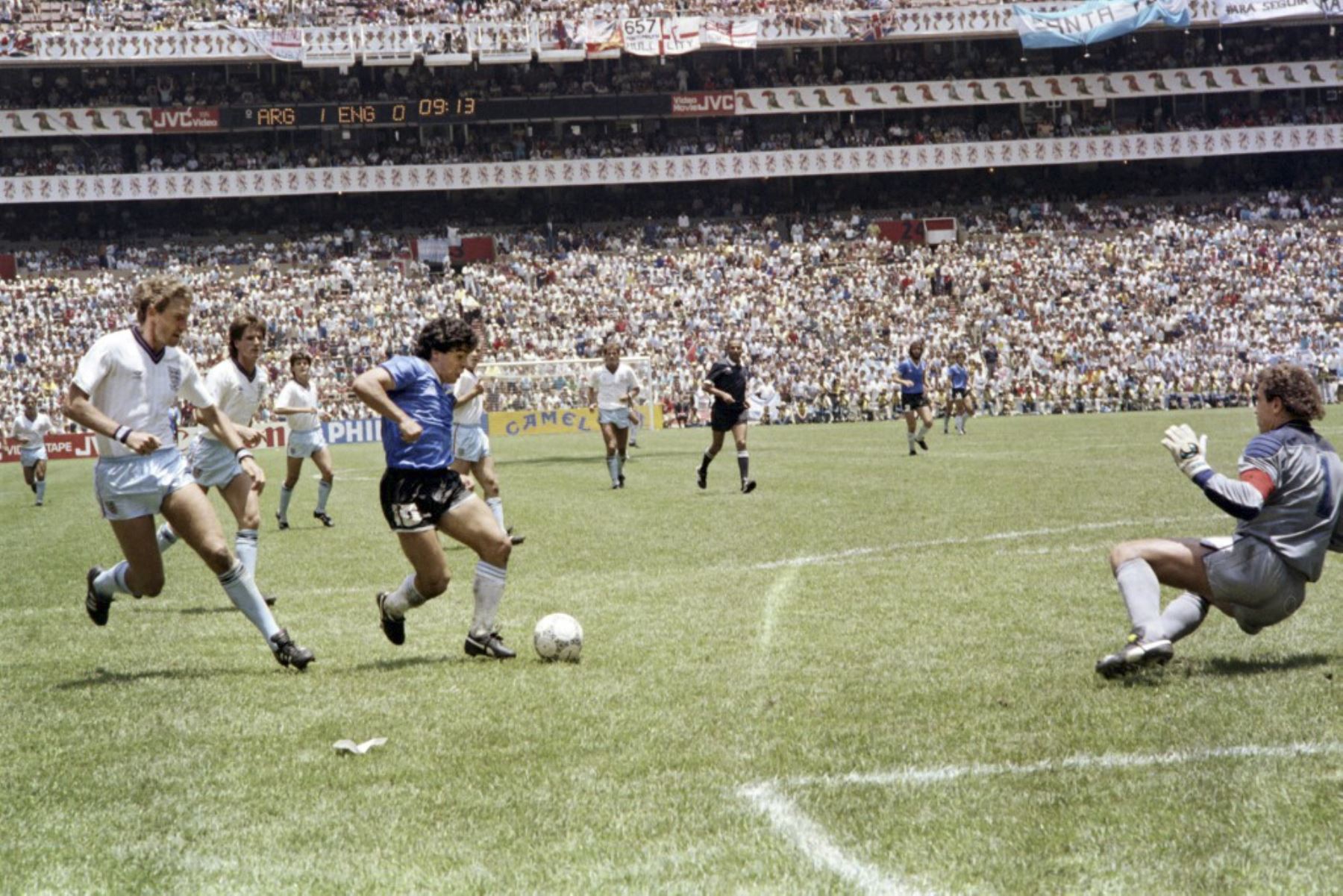 El mediocampista argentino Diego Maradona regatea a dos defensores ingleses el 22 de junio de 1986 en la Ciudad de México durante el partido de cuartos de final de la Copa del Mundo entre Argentina e Inglaterra. Maradona anotó dos goles, el primero con la mano izquierda cuando saltó hacia el balón frente al portero Peter Shilton, mientras Argentina venció a Inglaterra 2-1. Foto: AFP